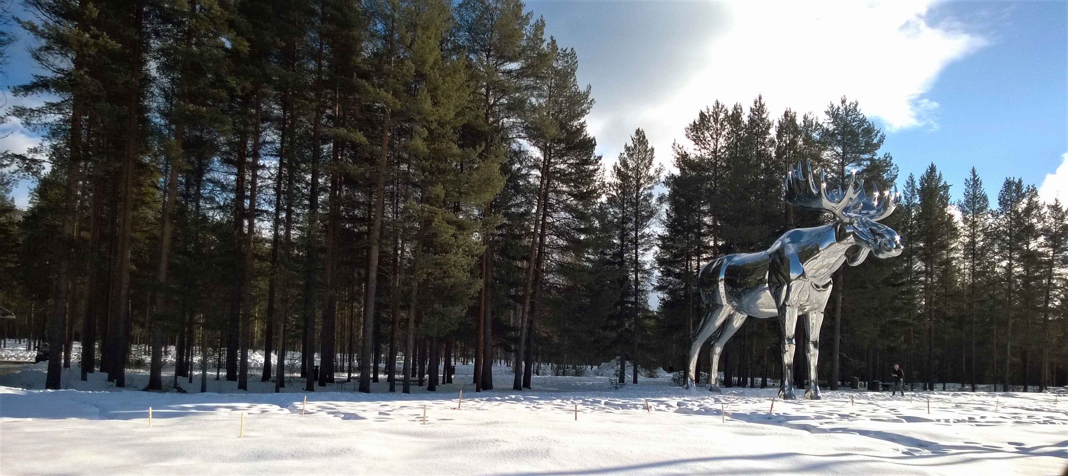 Silver moose statue near tree photo