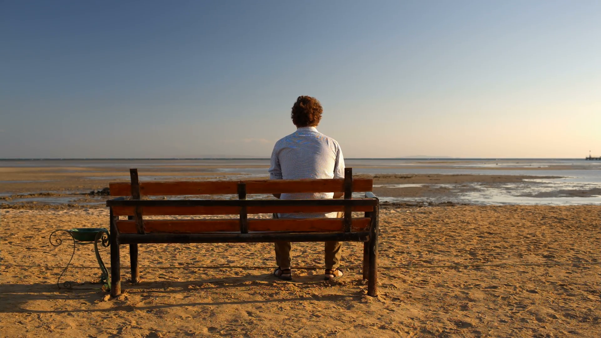 Young man sitting alone on the bench on the beach Stock Video ...