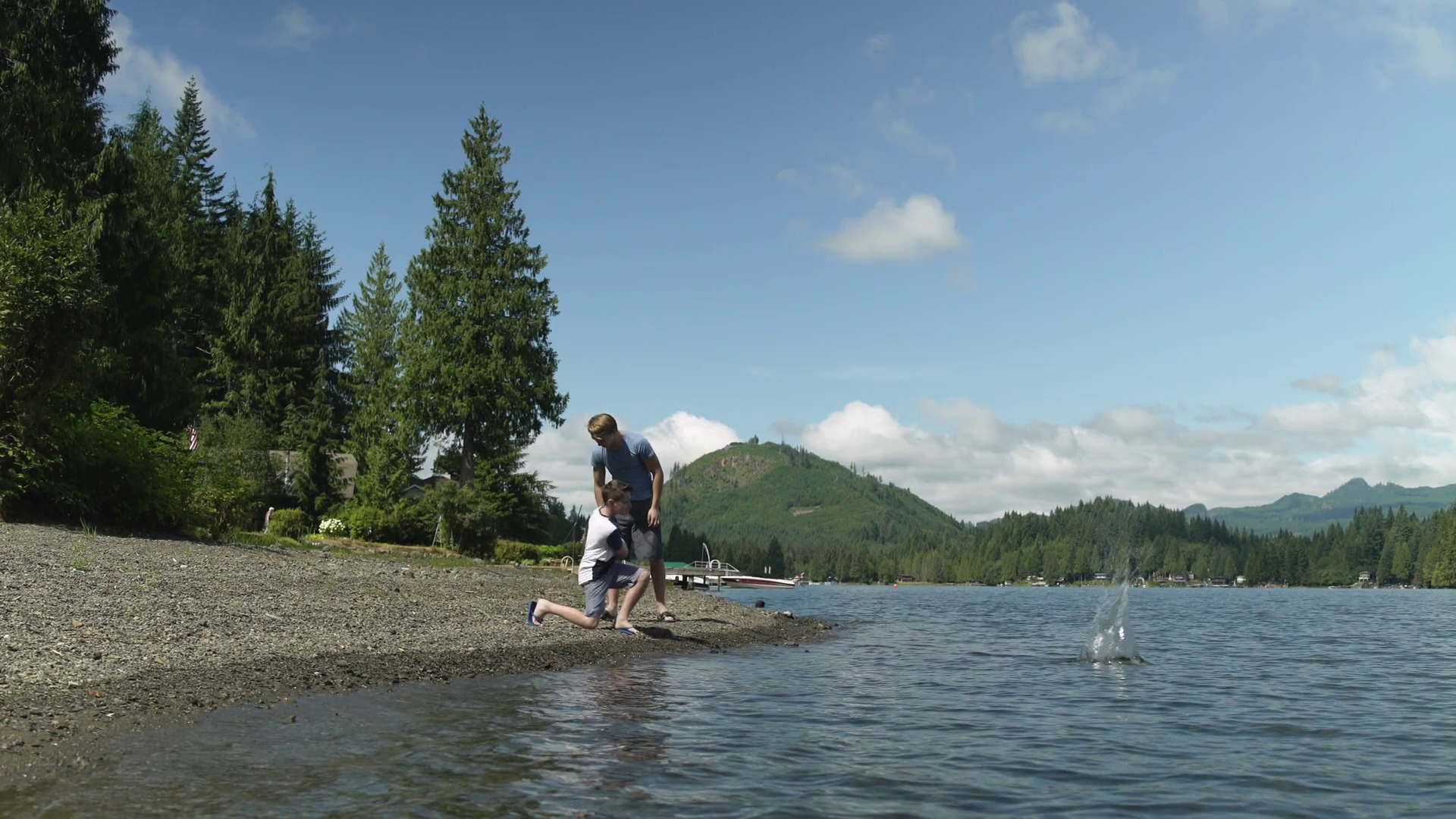 Brothers skimming stones by waters edge, Lake Connaught, Washington ...