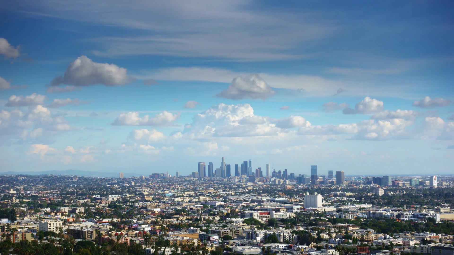 White clouds in blue sky over city of Los Angeles cityscape. 4K UHD ...