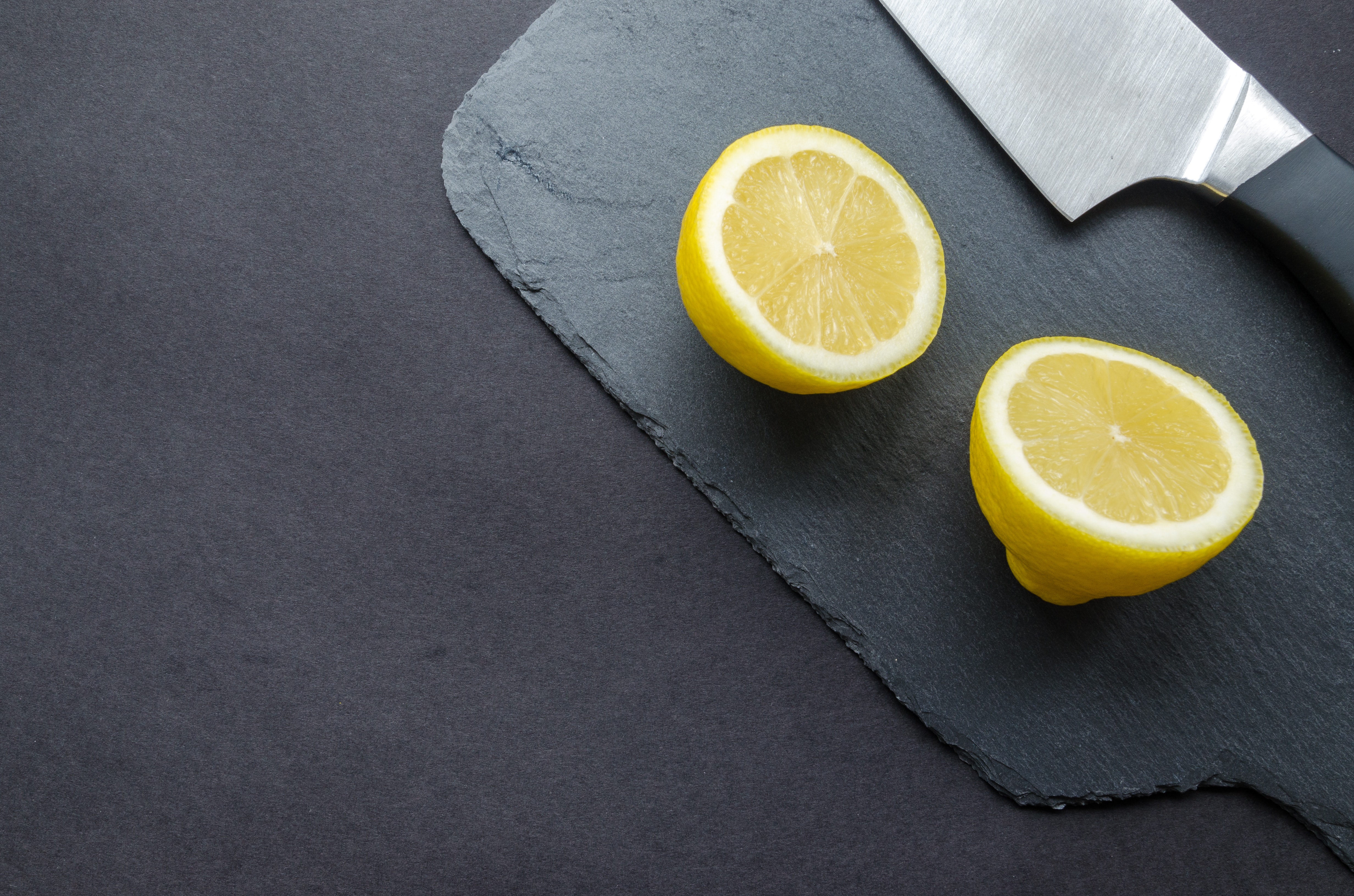 Sliced Lemon Beside Knife on Top of Black Surface, Black, Knife, Texture, Table, HQ Photo