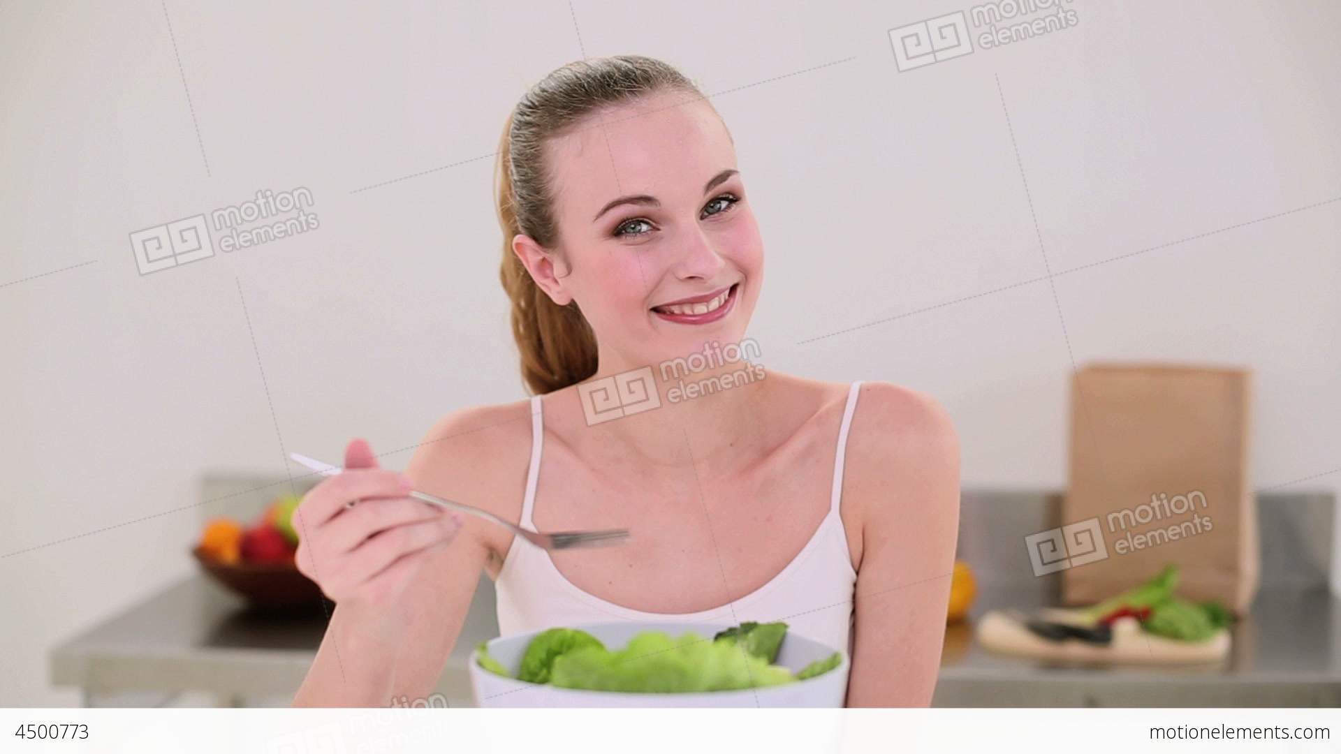 Smiling Model Eating A Big Bowl Of Salad Stock video footage | 4500773