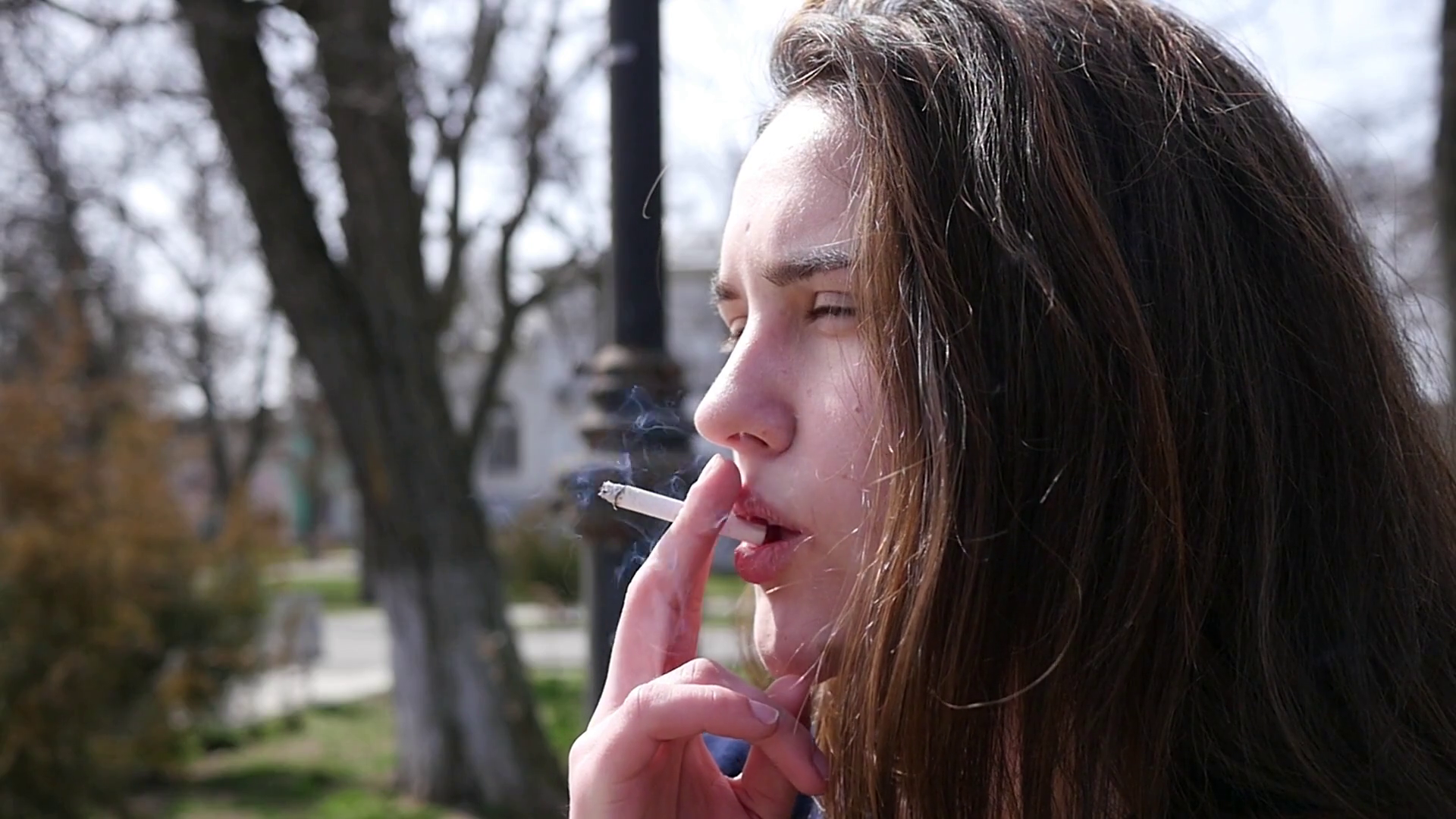 Closeup pretty young girl smoking cigarette exhaling in slow motion ...