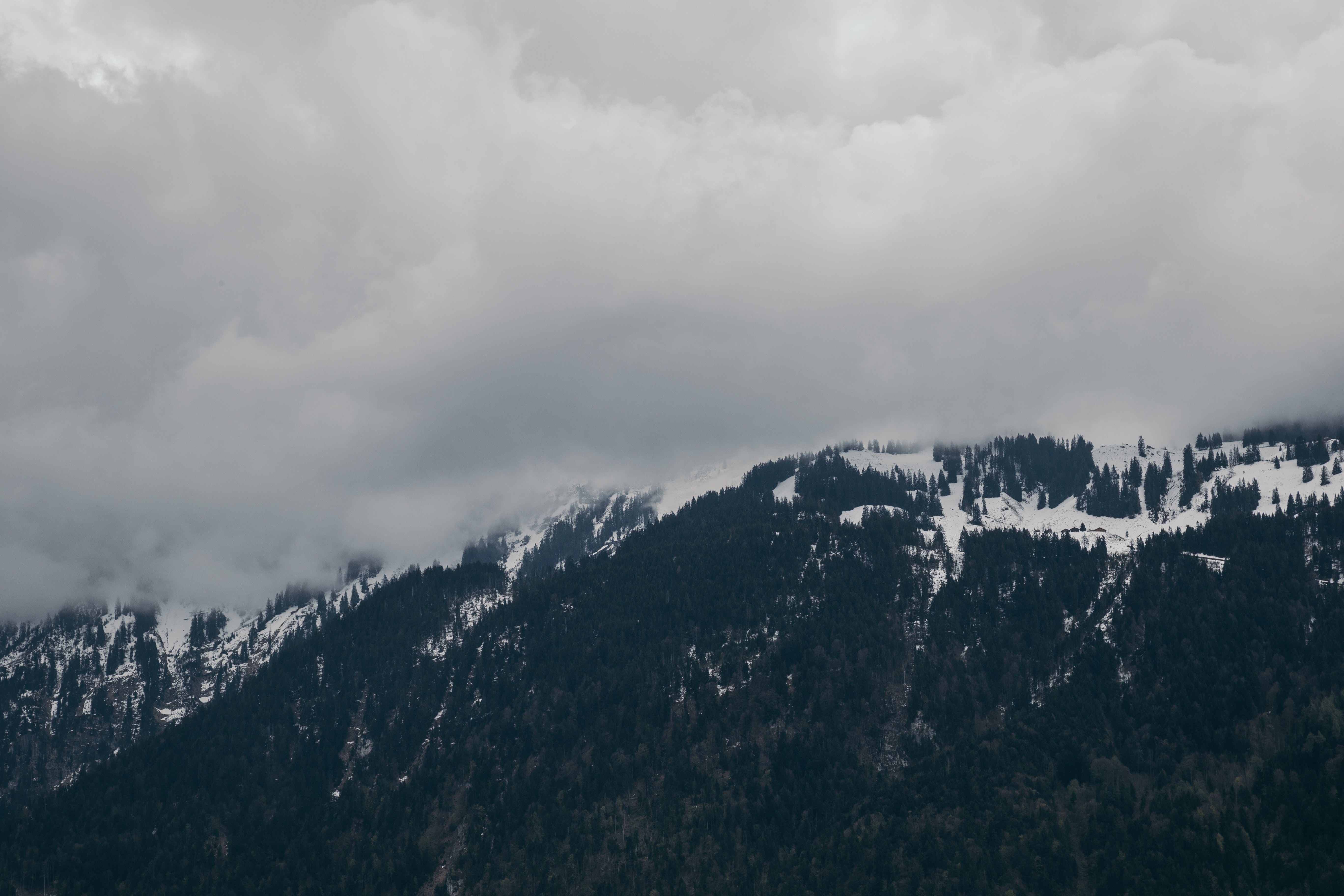 Snow-capped mountain under cloudy sky photo