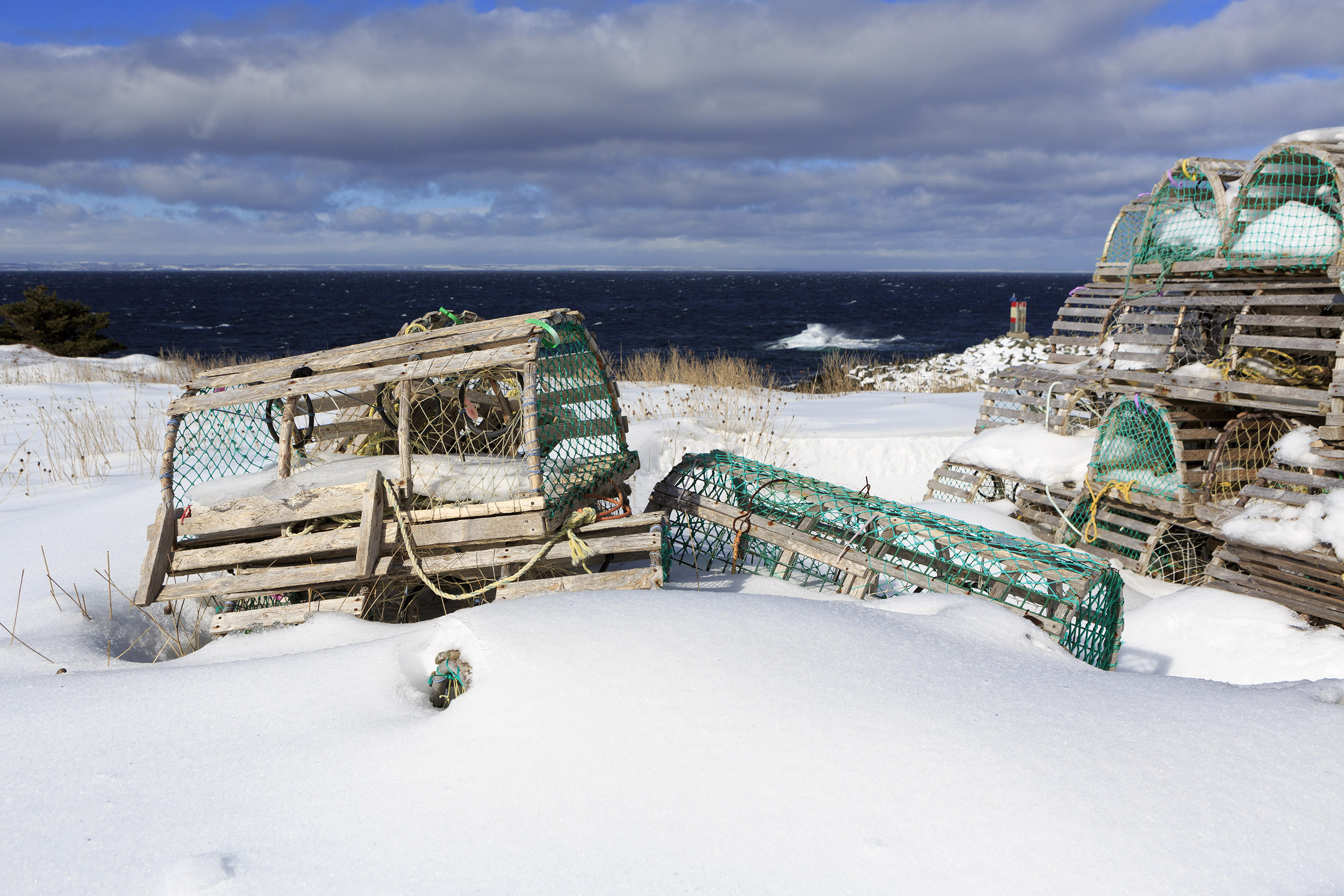 Snow covered lobster traps near ocean photo