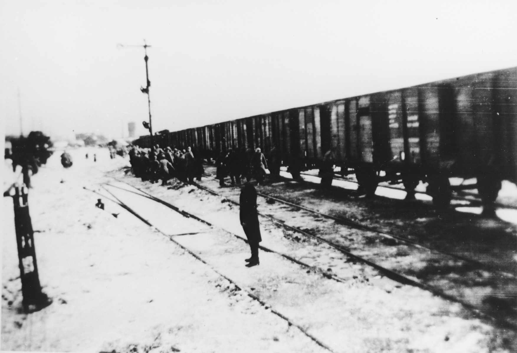 A German stands guards on a snow-covered railroad track as a group ...