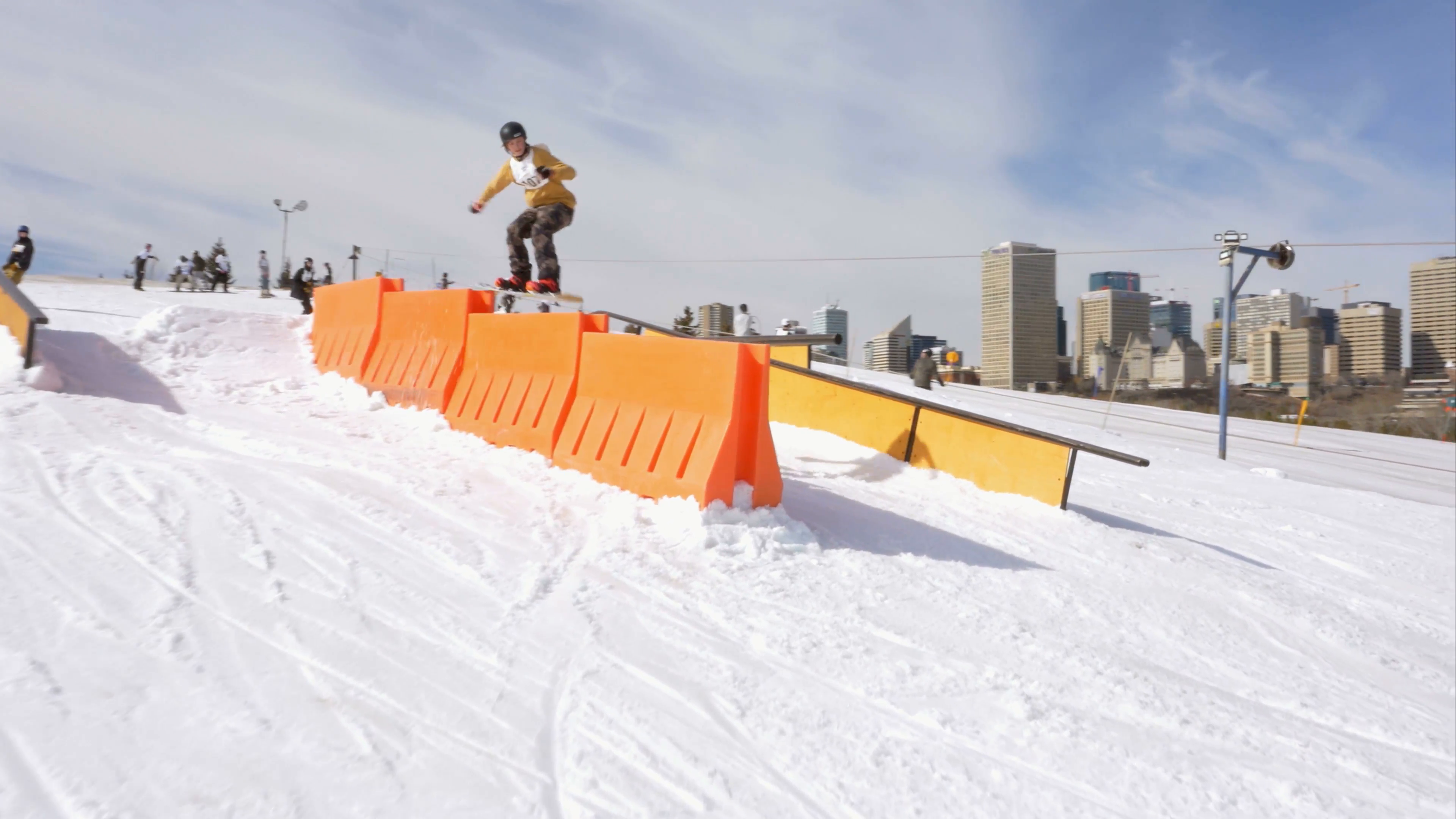 Snowboarder performs board slide to 180 on obstacle course steps ...