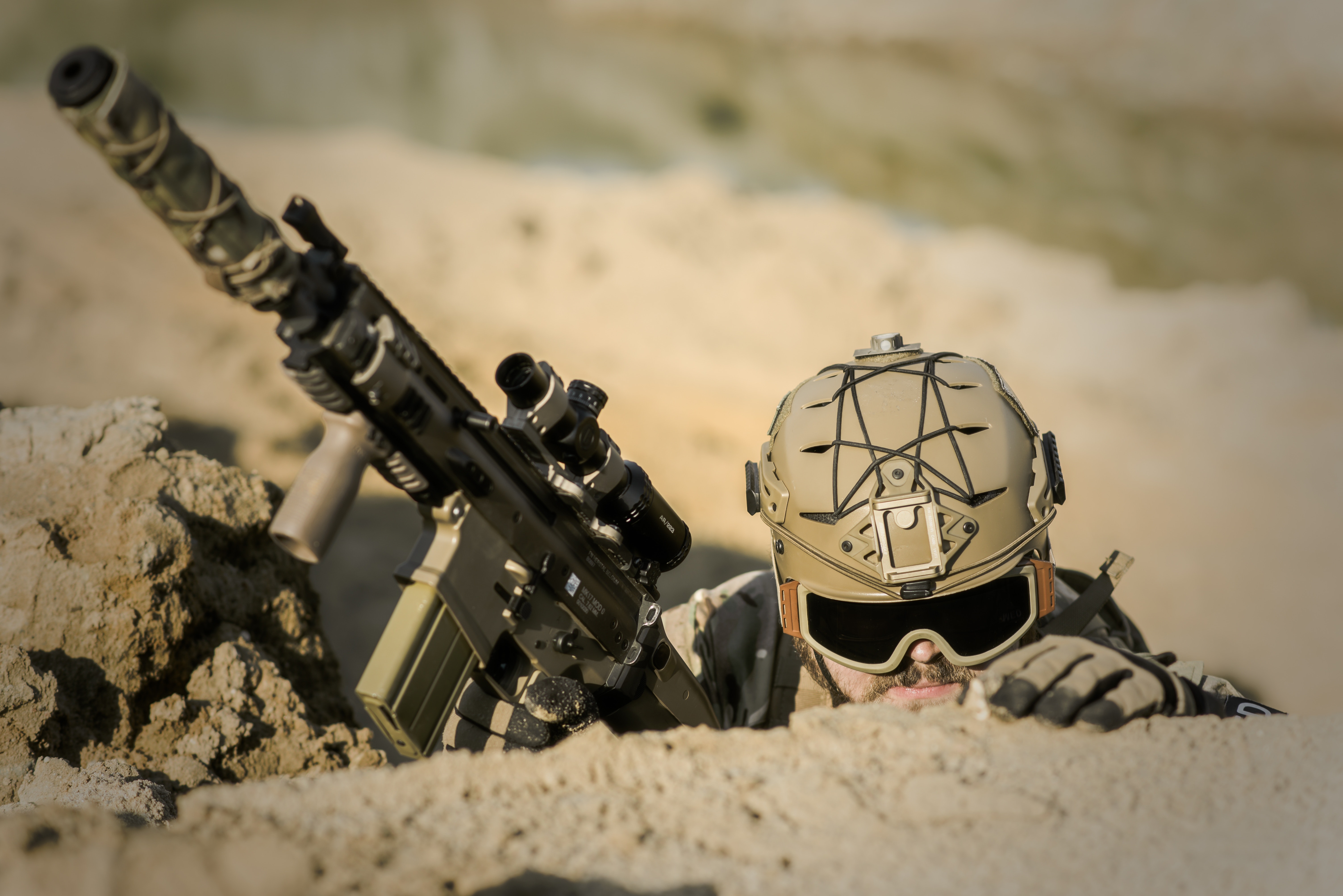 Soldier wearing brown helmet holding assault rifle during daytime photo