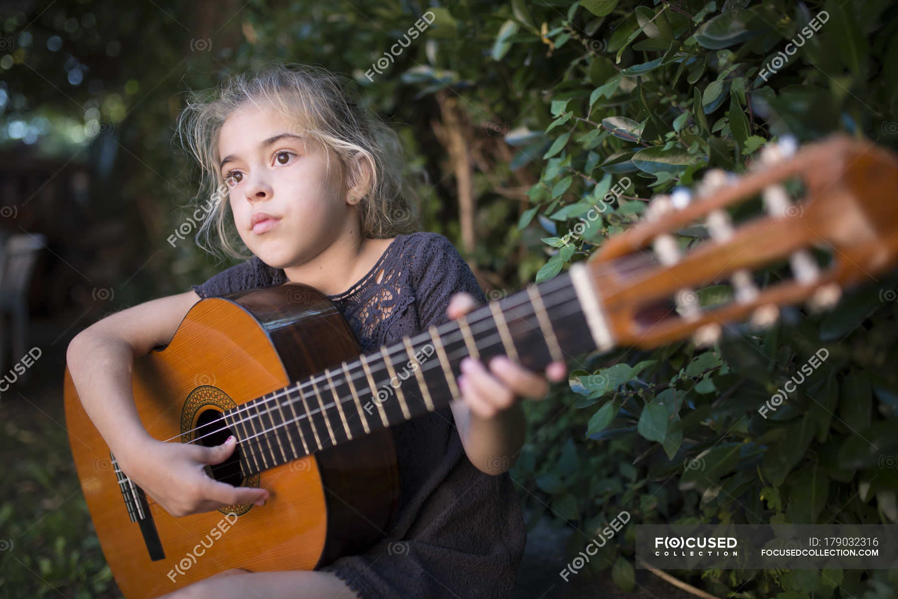 Girl playing spanish guitar outdoors — Stock Photo | #179032316