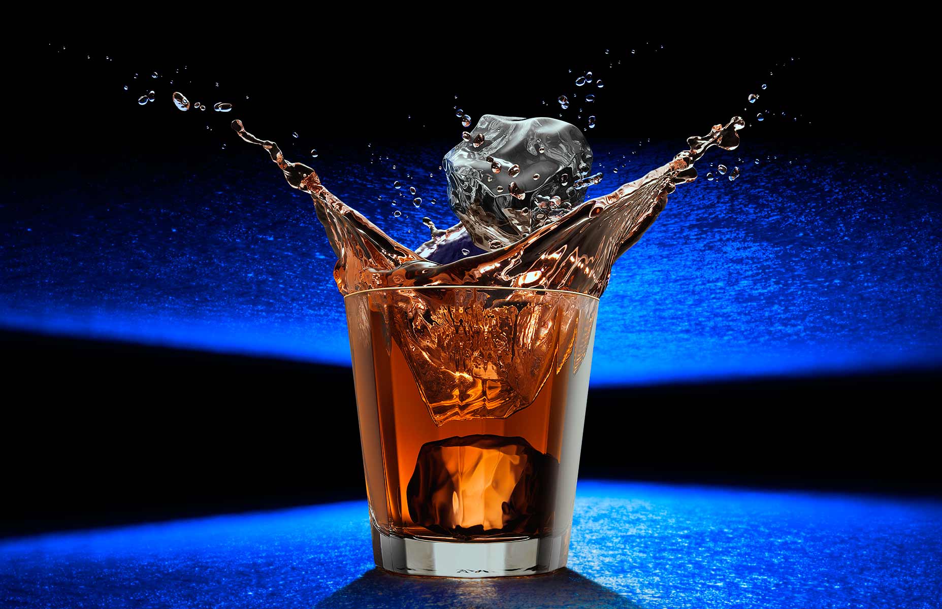 Ice drop whiskey splash photograph on a futuristic blue surface by ...