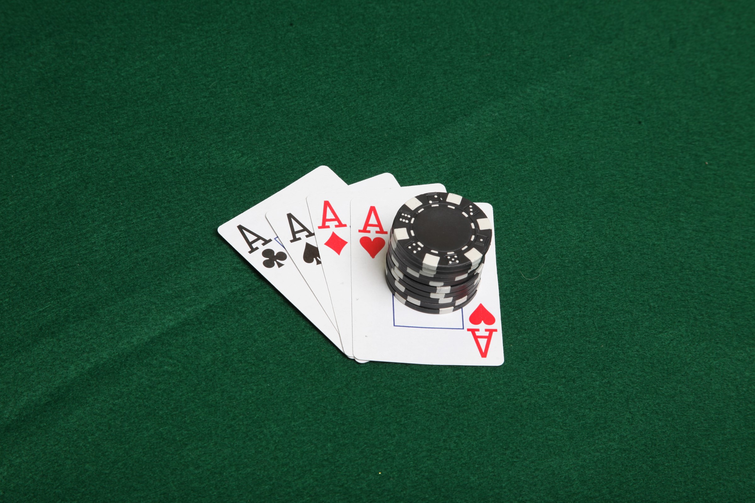 Stack of black poker chips on four aces. photo