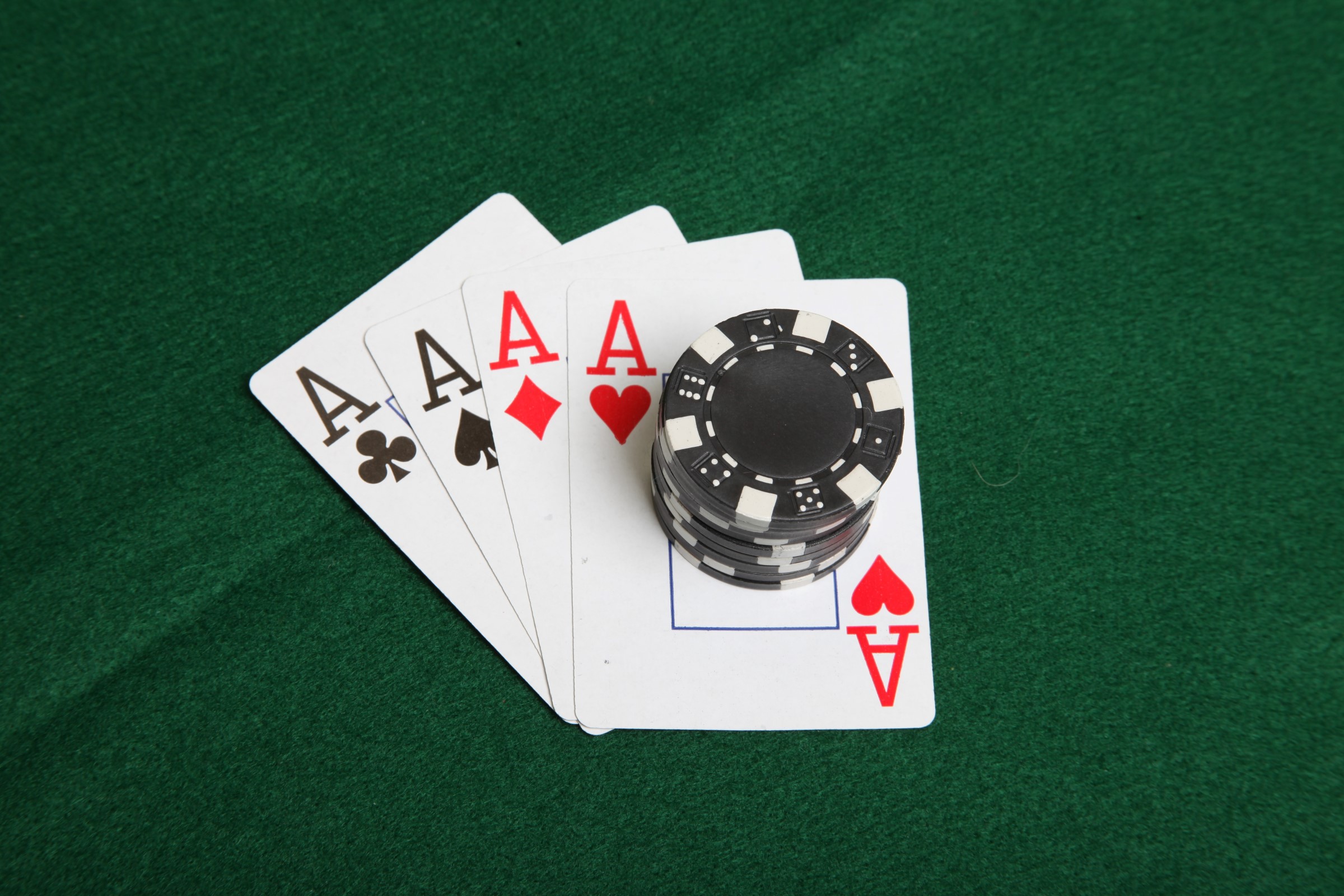 Stack of black poker chips on four aces. photo