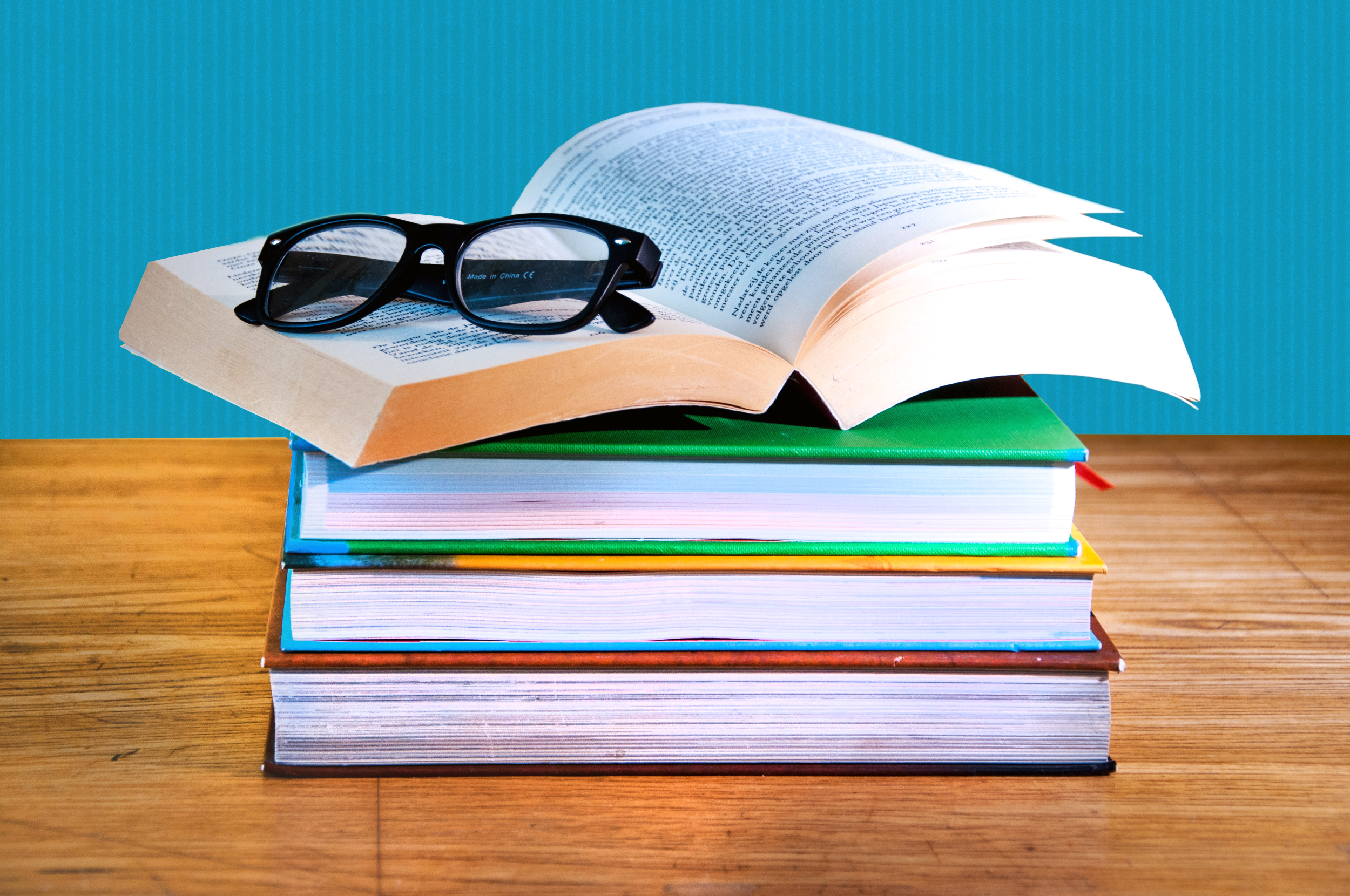 Stack of books with a pair of eyeglasses photo