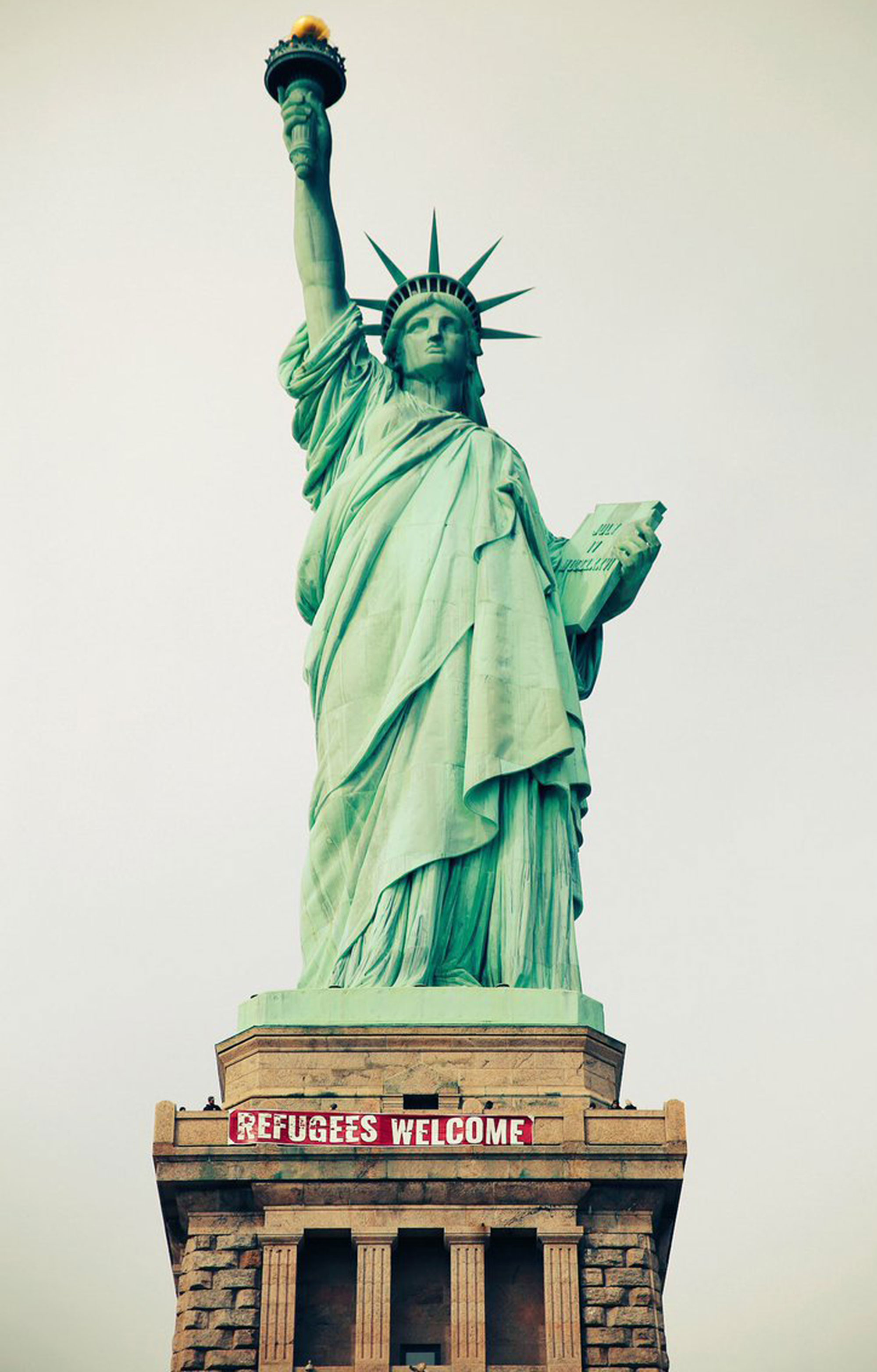 Refugees Welcome' Banner on Statue of Liberty | PEOPLE.com