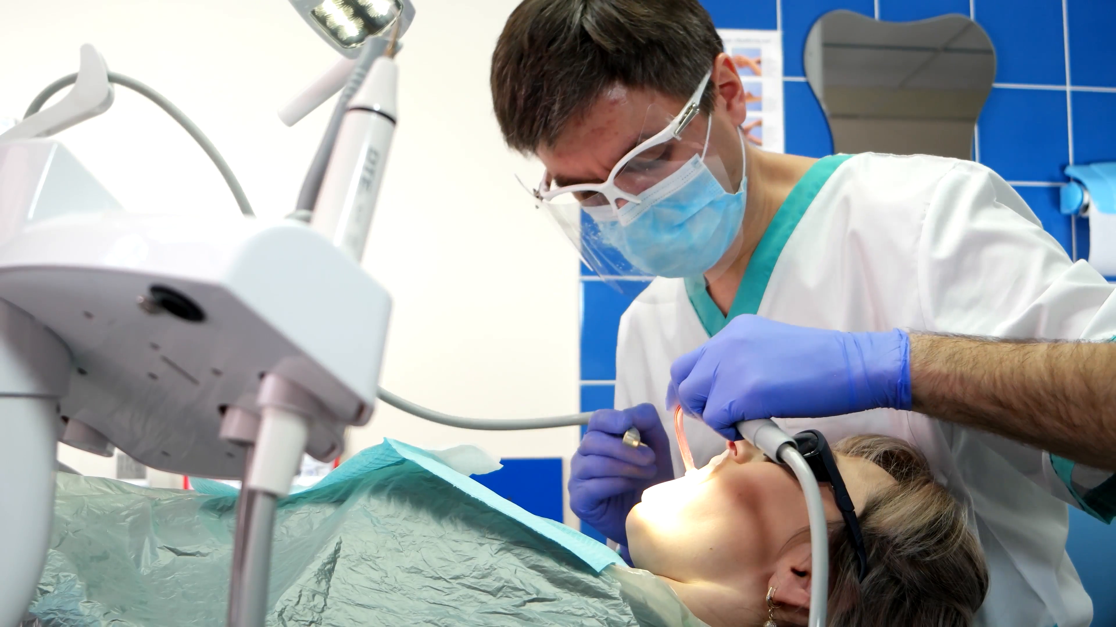 Doctor working with dental equipment and treats a patient ...