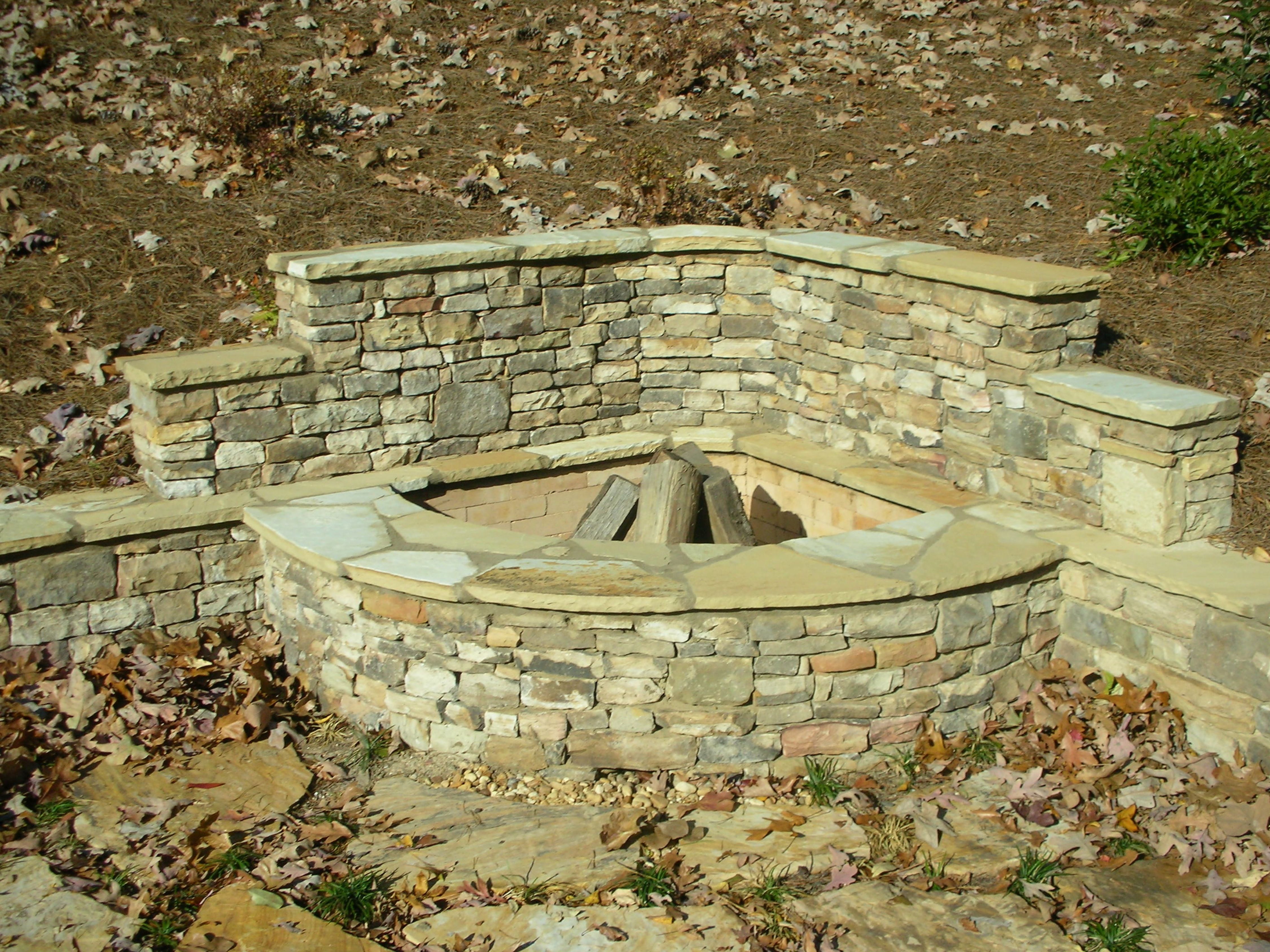Stacked Stone Corner Firepit with Retaining Wall | Fireplaces and ...