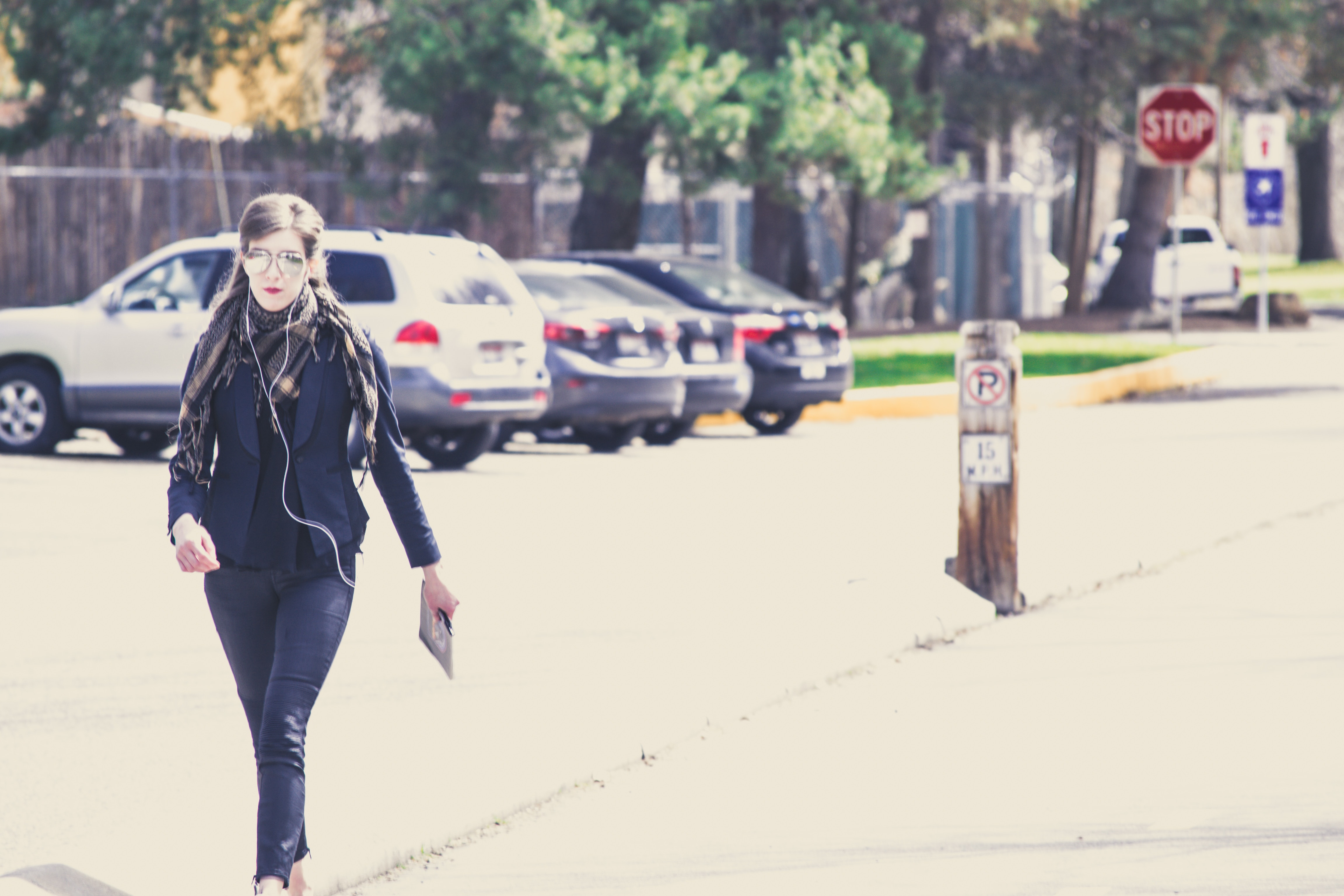 Stylish girl in sunglasses and suit walking down the street and listening to music photo