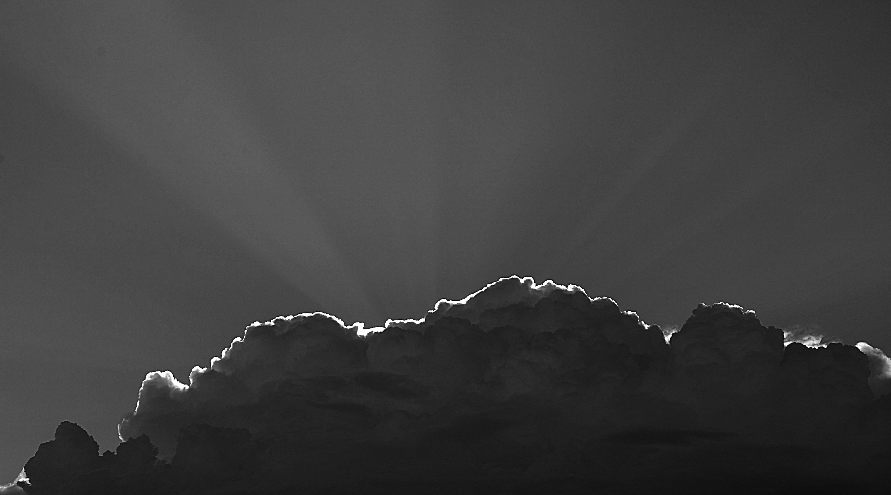 Sun rays piercing through gray clouds photo