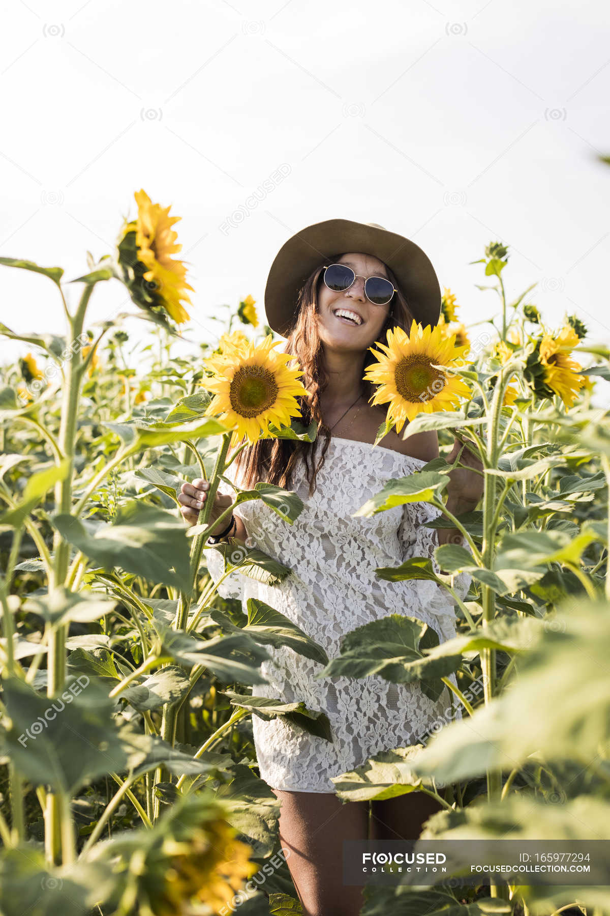 Woman standing in sunflower field — Stock Photo | #165977294