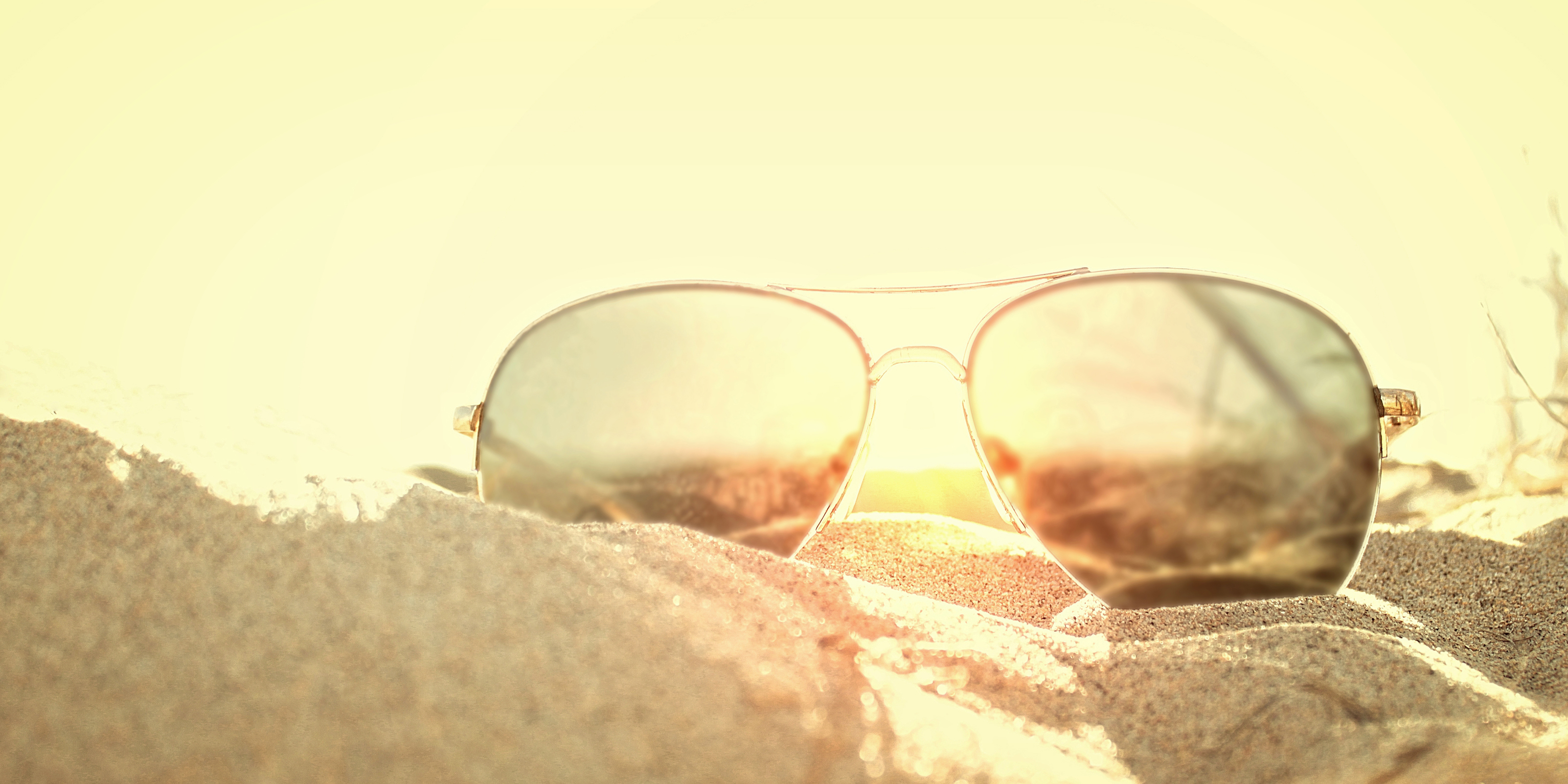 Sunglasses on the sand at sunse photo