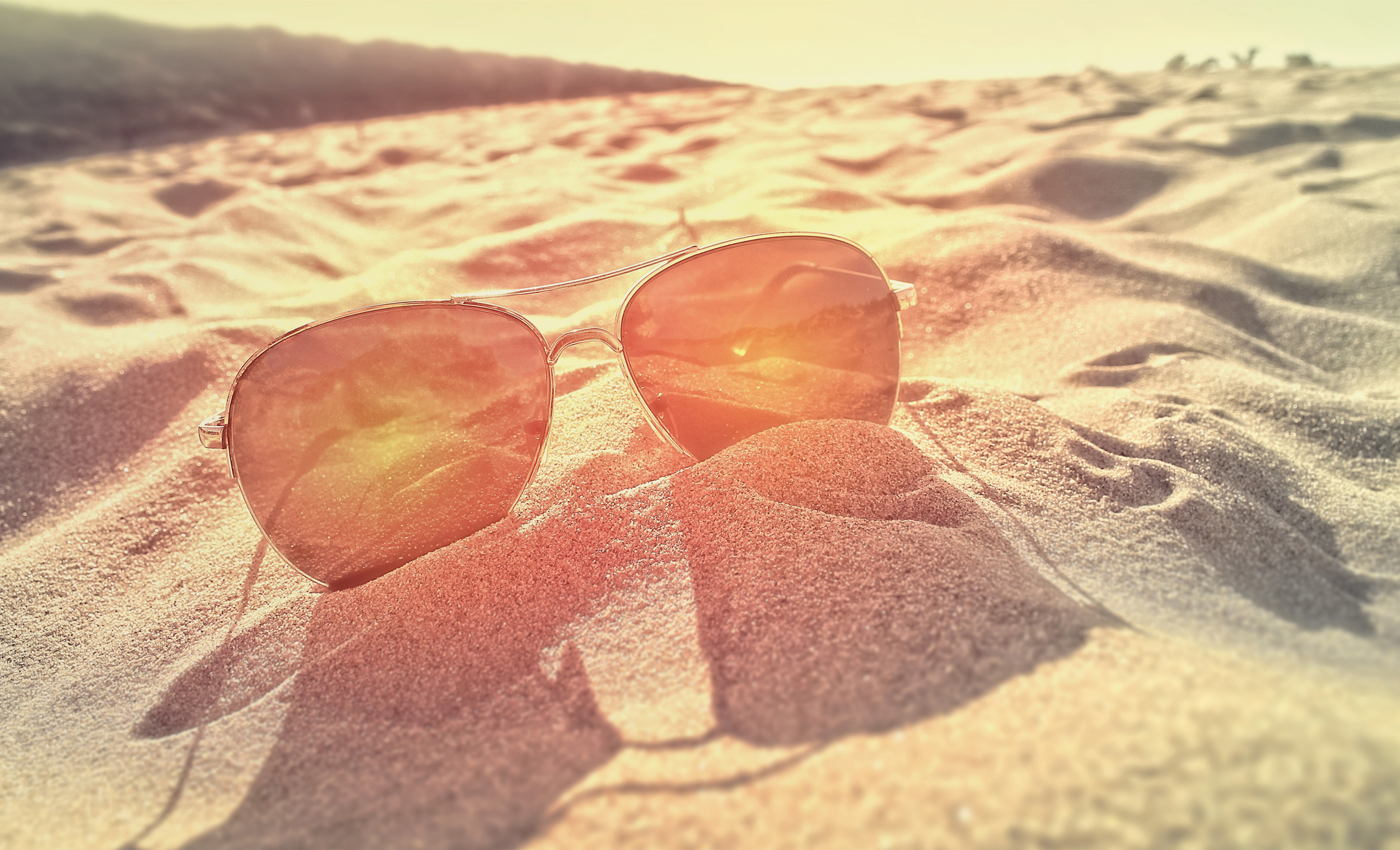 Sunglasses on the sand at sunset photo