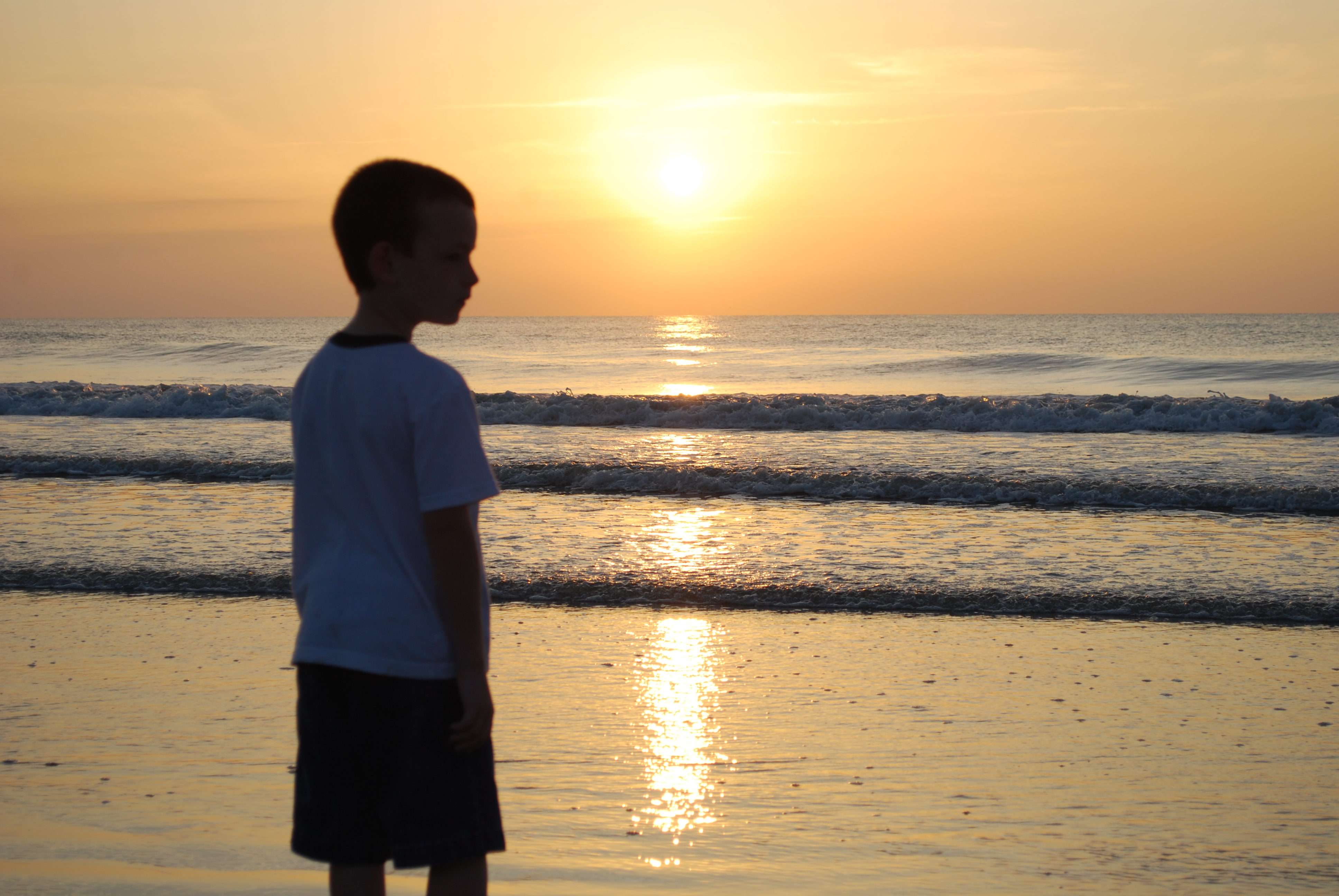 Sunrise at beach with boy photo