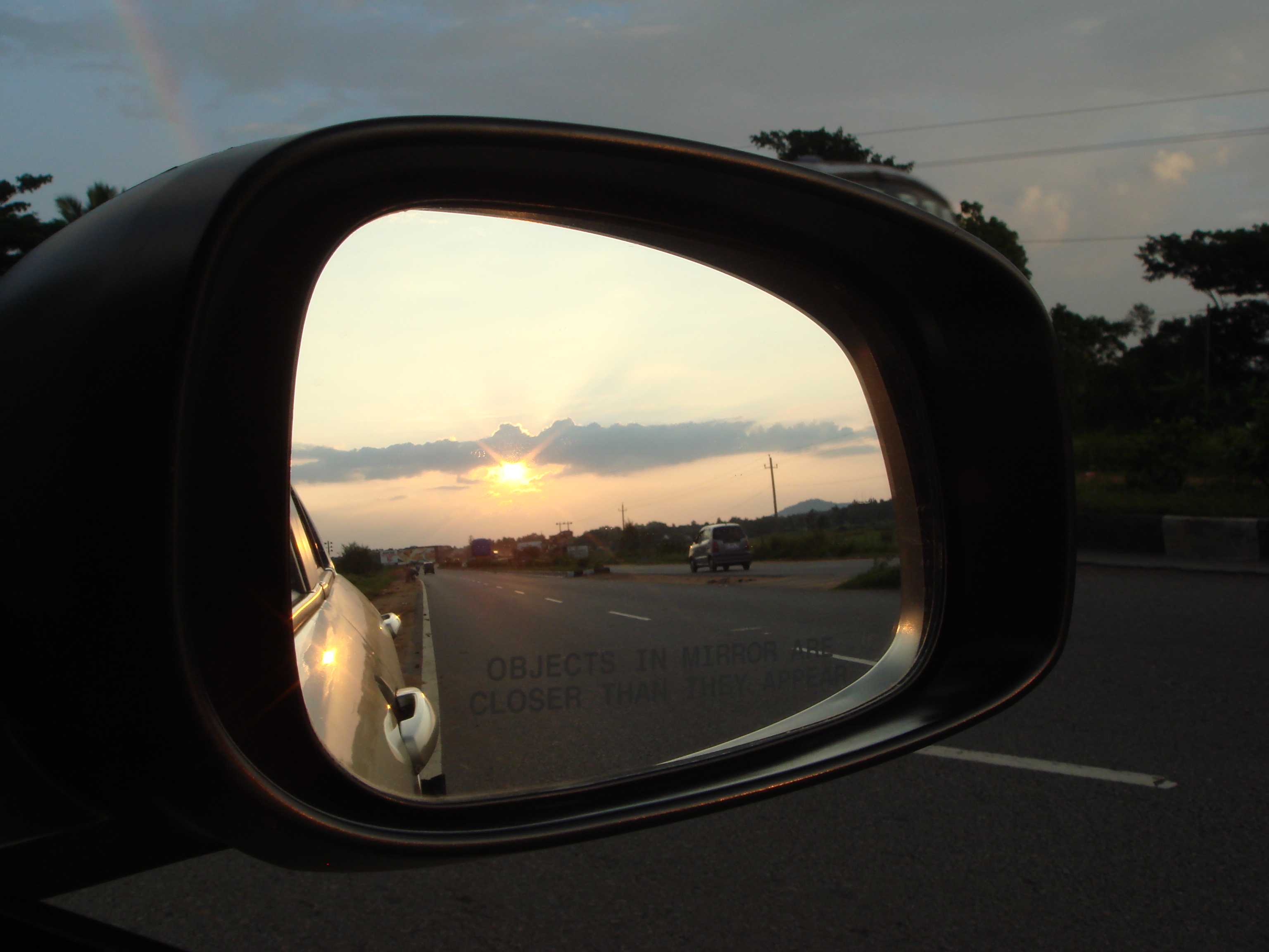 Sunrise in car mirror photo