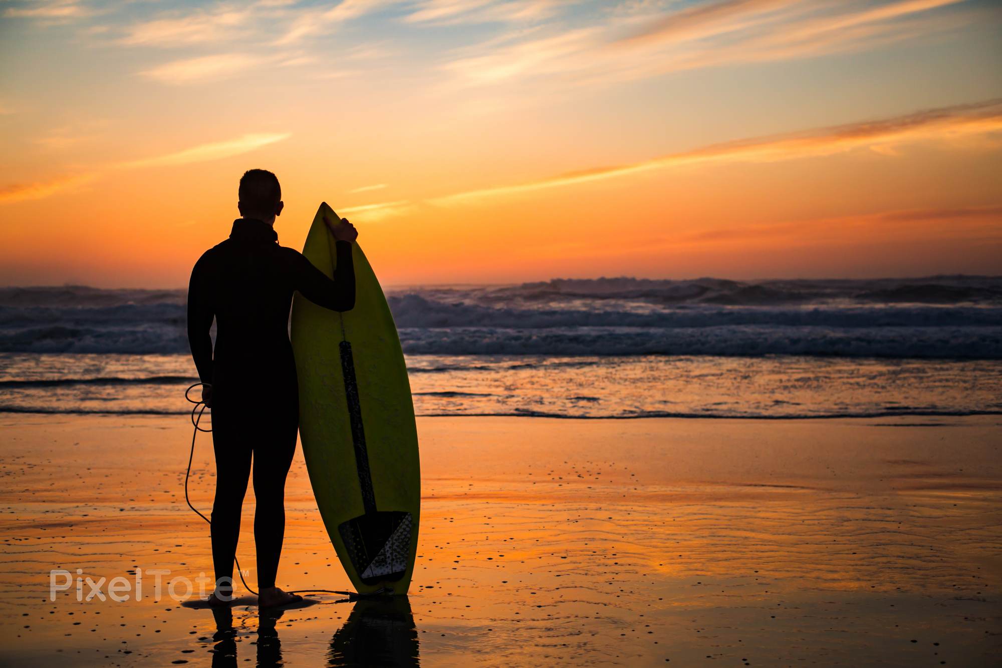 Male Surfer with a Surfboard Standing on a Beach Watching Sunset ...