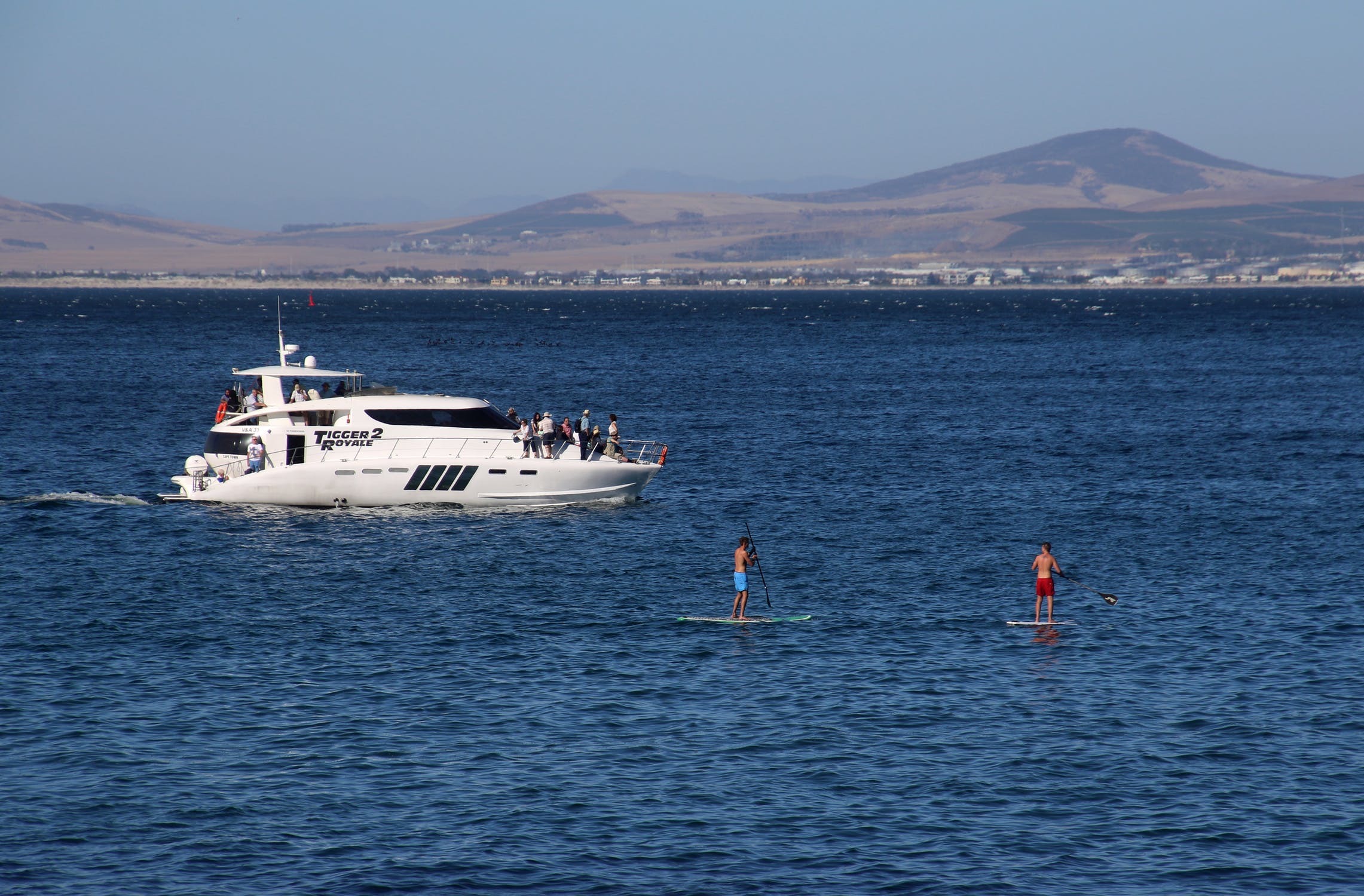 Surfers near the yacht at the sea photo