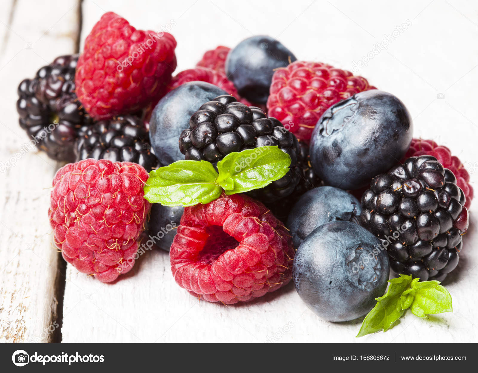 Ripe and sweet berries on white wooden background — Stock Photo ...