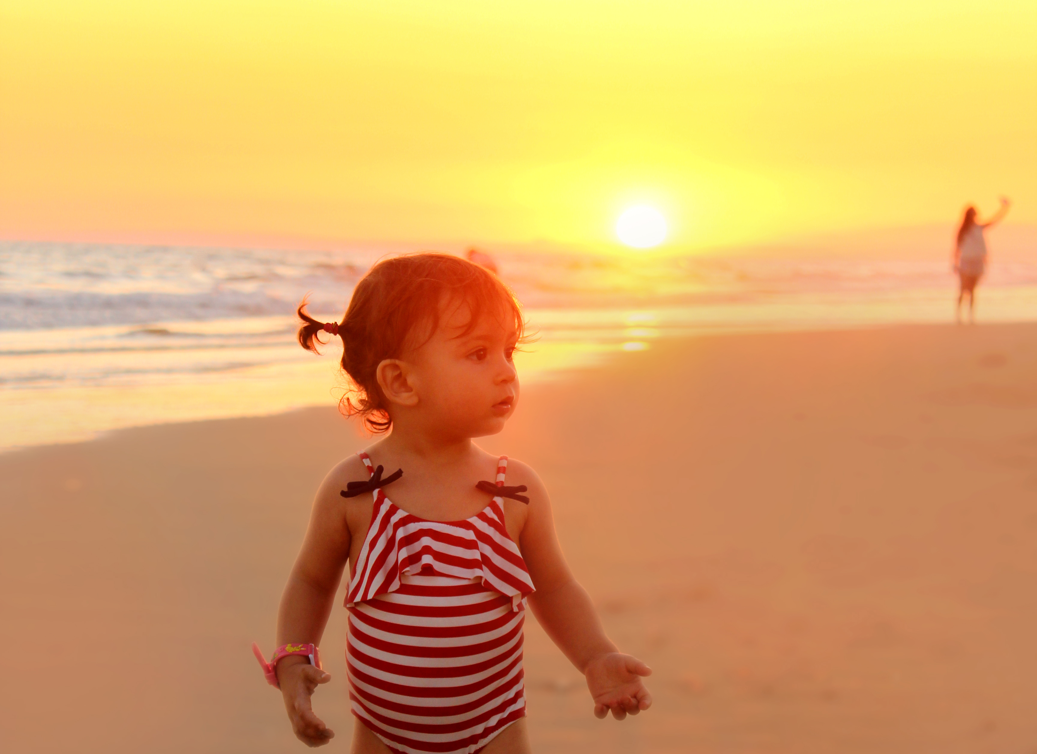 Sweet little girl on the beach at sunset photo
