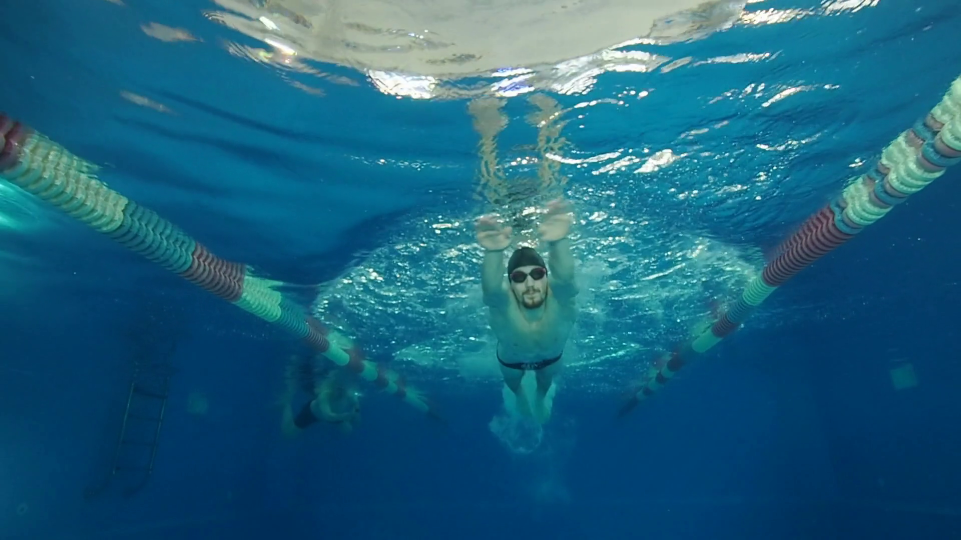 Man swimmer swims butterfly stroke in a swimming pool slow motion ...