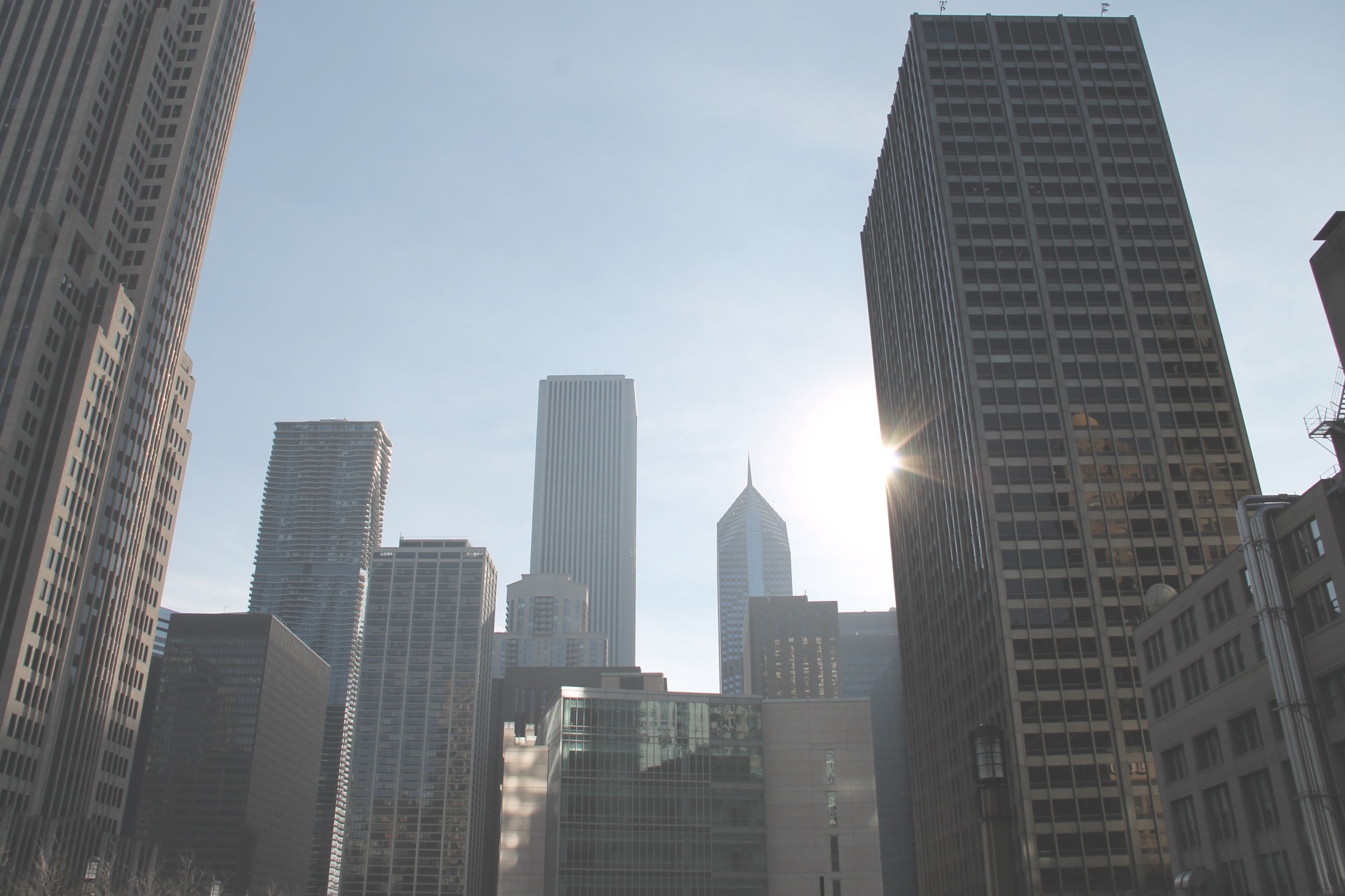 Free Stock Photo of Tall Skyscrapers with Sun in Clear Sky