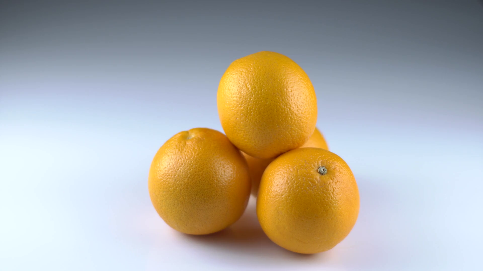 Close-up view of the four oranges taken by different hands of people ...