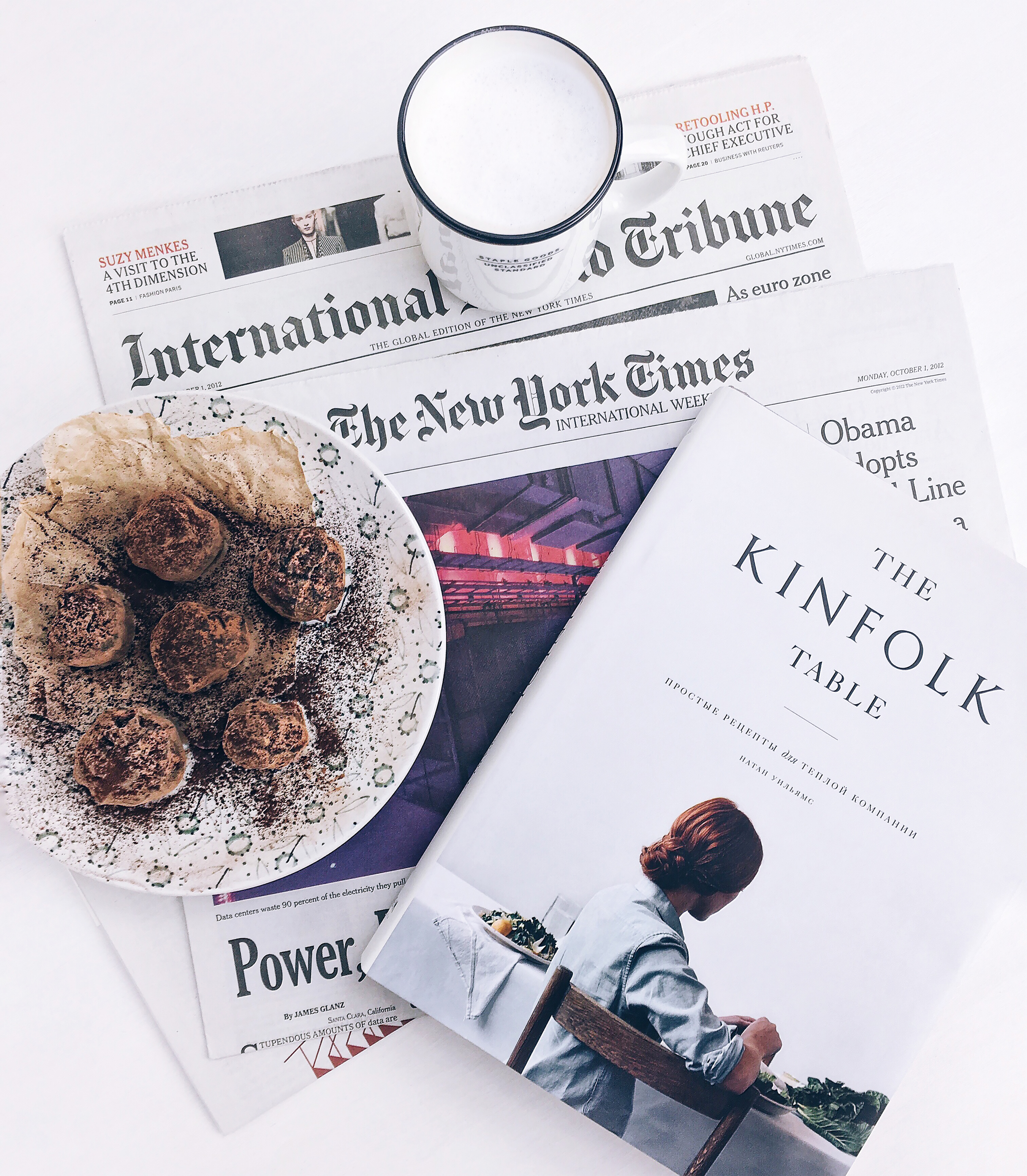 The kinfolk table book beside baked pastry on white ceramic plate with white ceramic mug photo