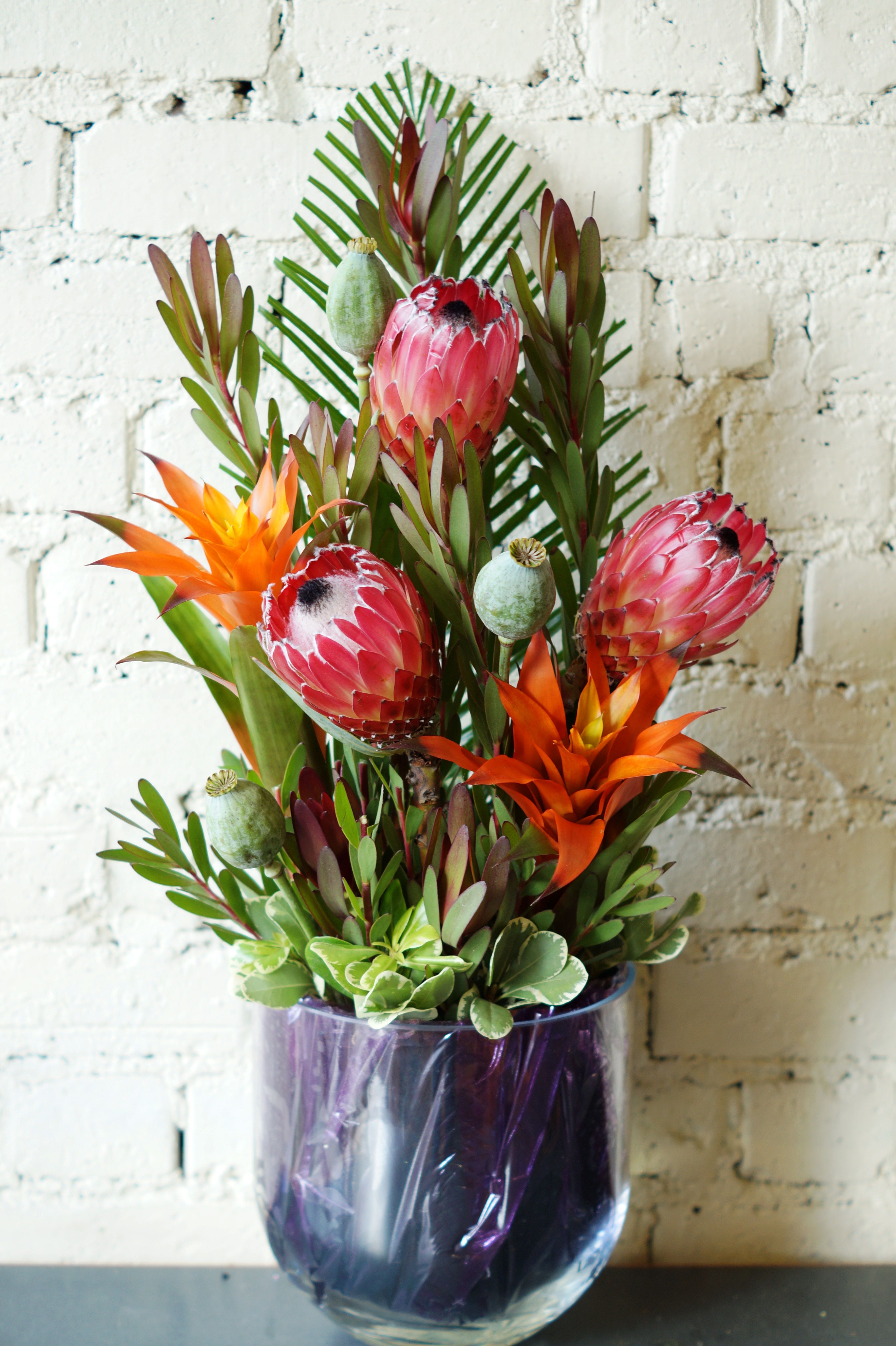 The main flowers used are orange Bromeliads and giant red Protea ...