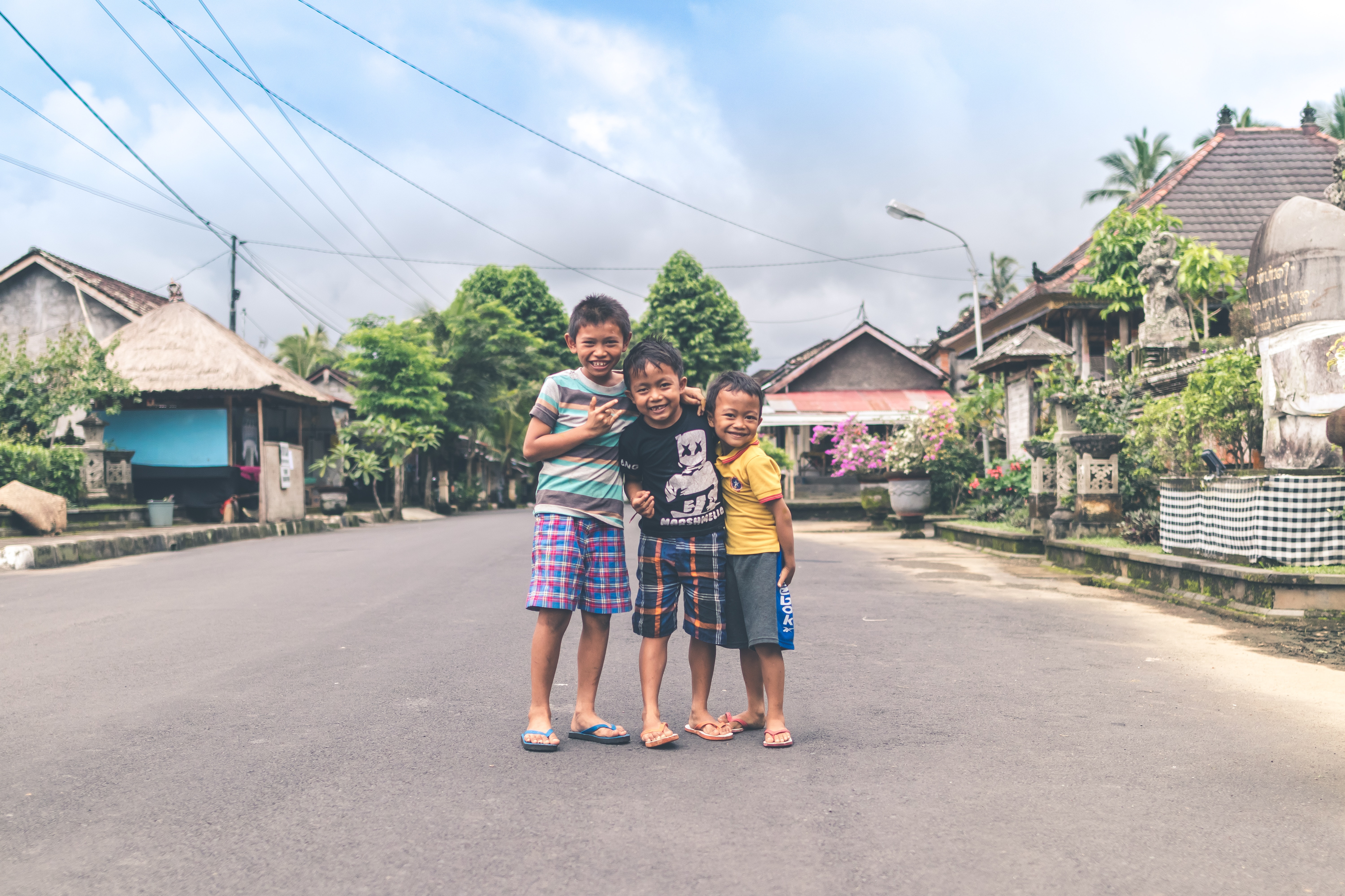 Three boys standing on road photo