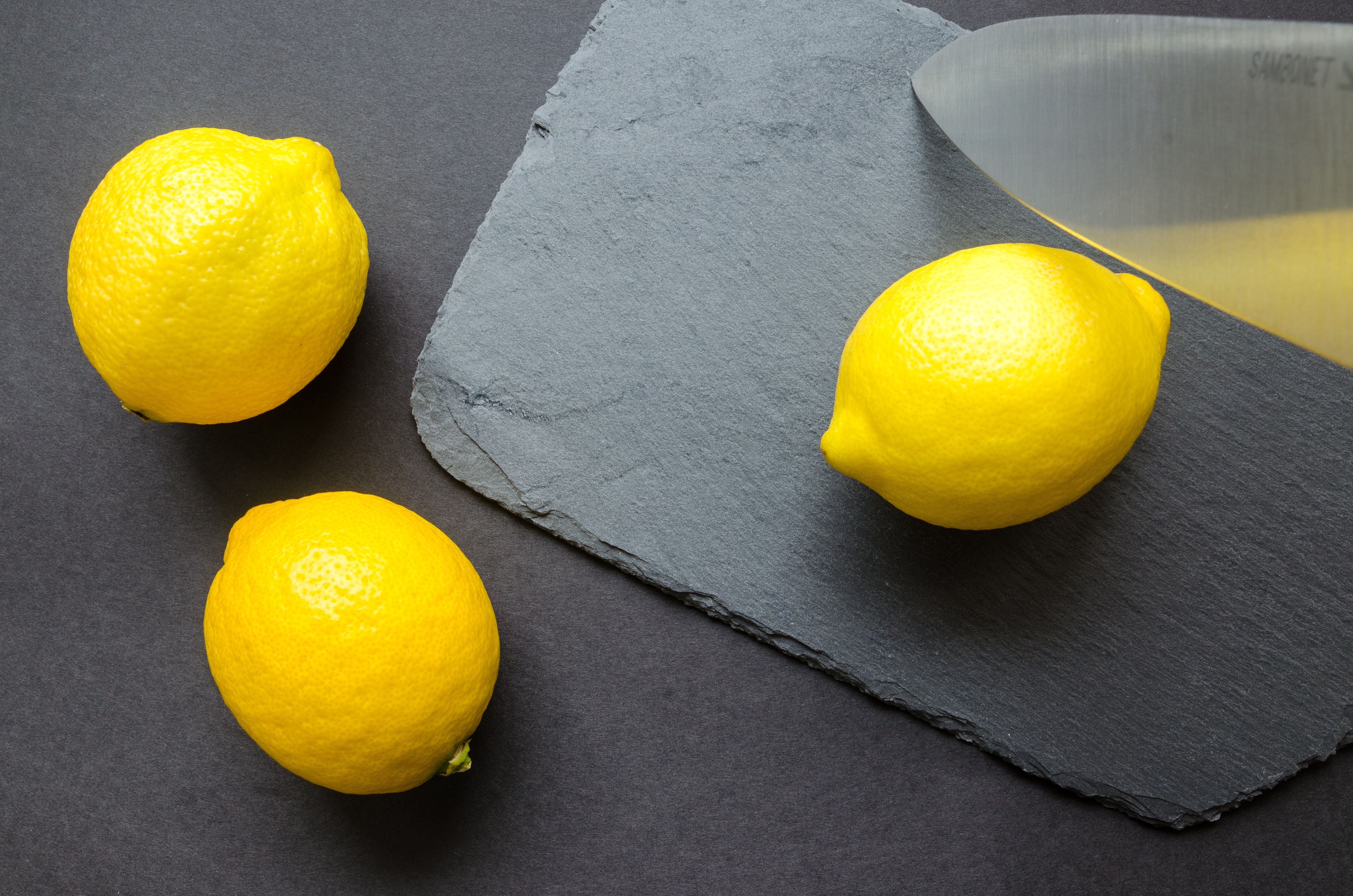 Three lemons on grey surface photo