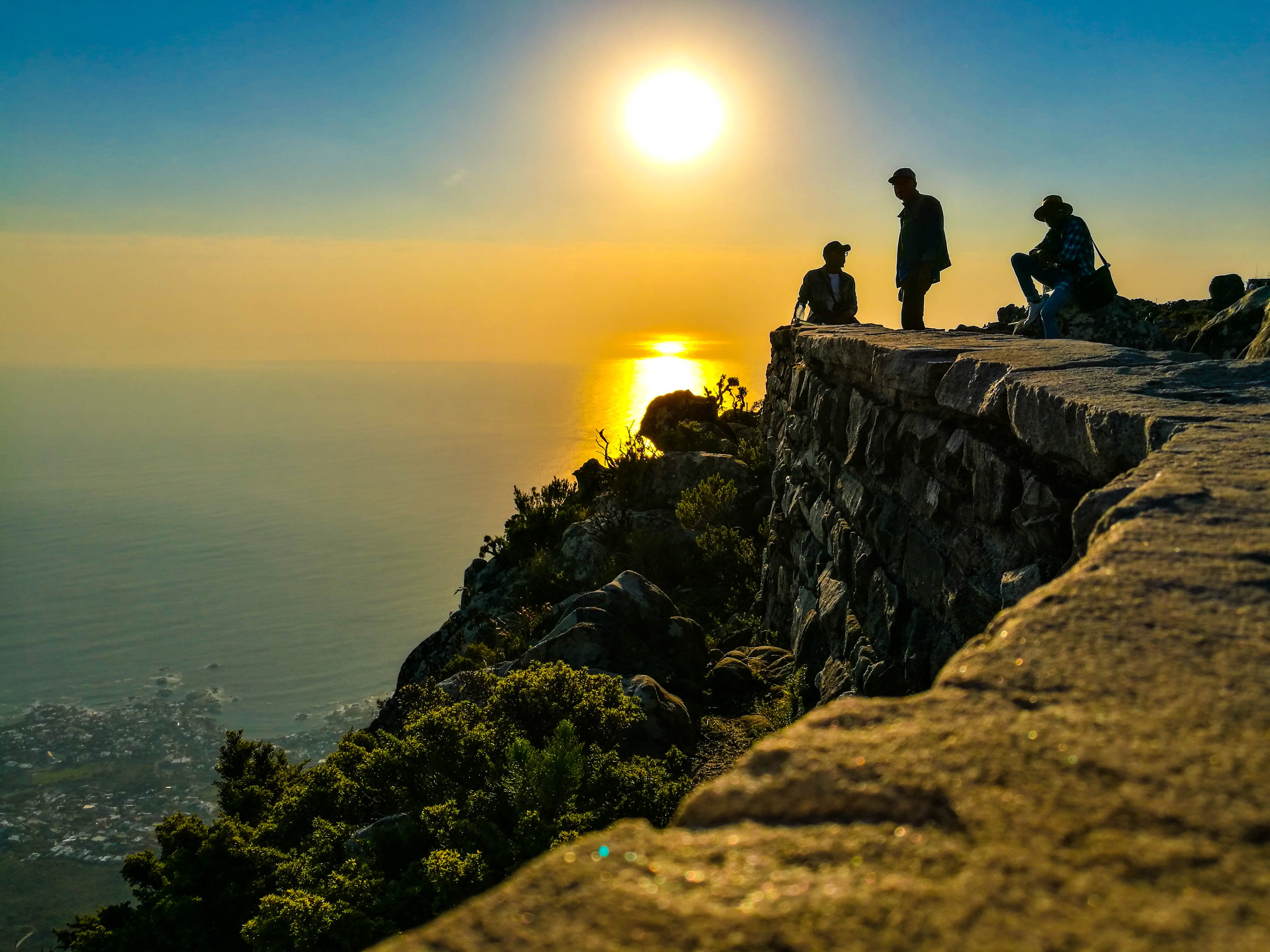 Three men on mountain cliff photo