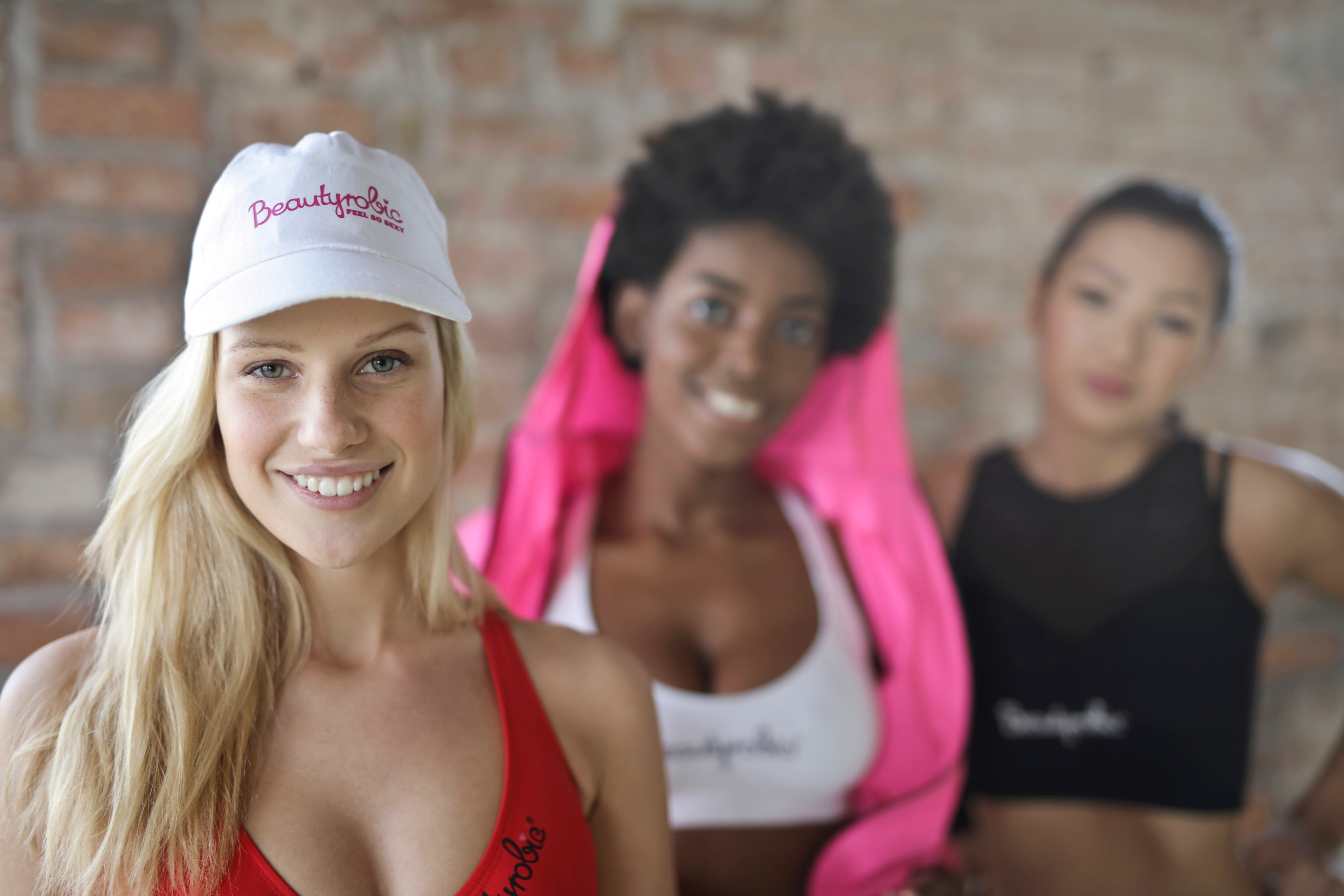 Three woman wearing of red, white, and black sport bras photo