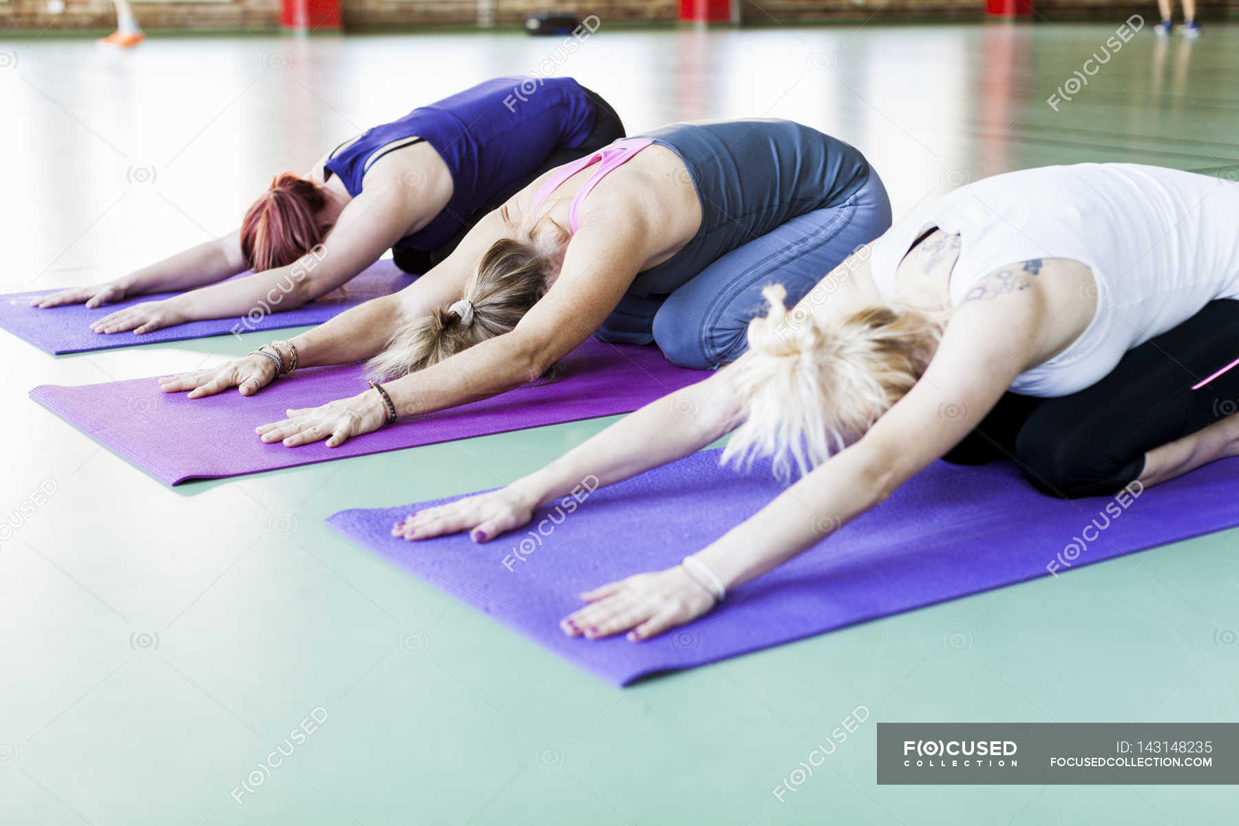 Women exercising on yoga mats — Stock Photo | #143148235