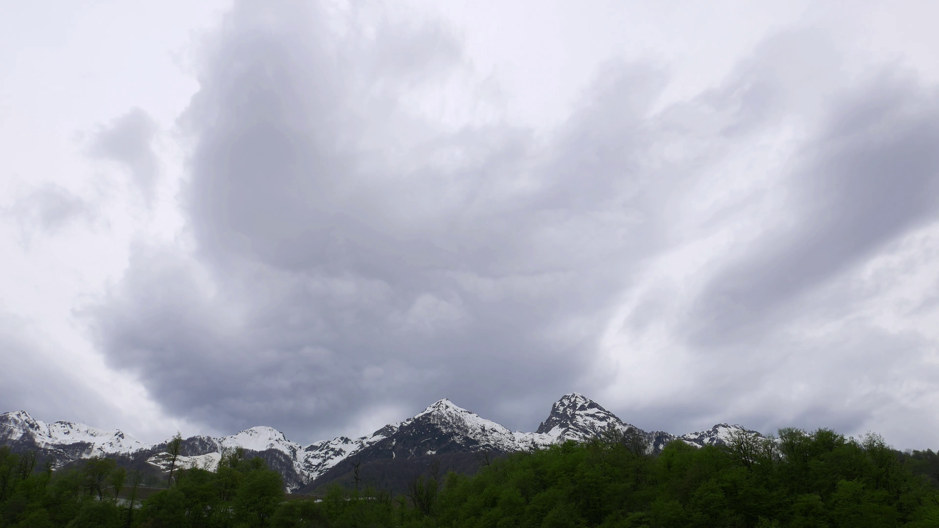 Gray clouds fly towards over rocky mounts, time lapse shot, low ...