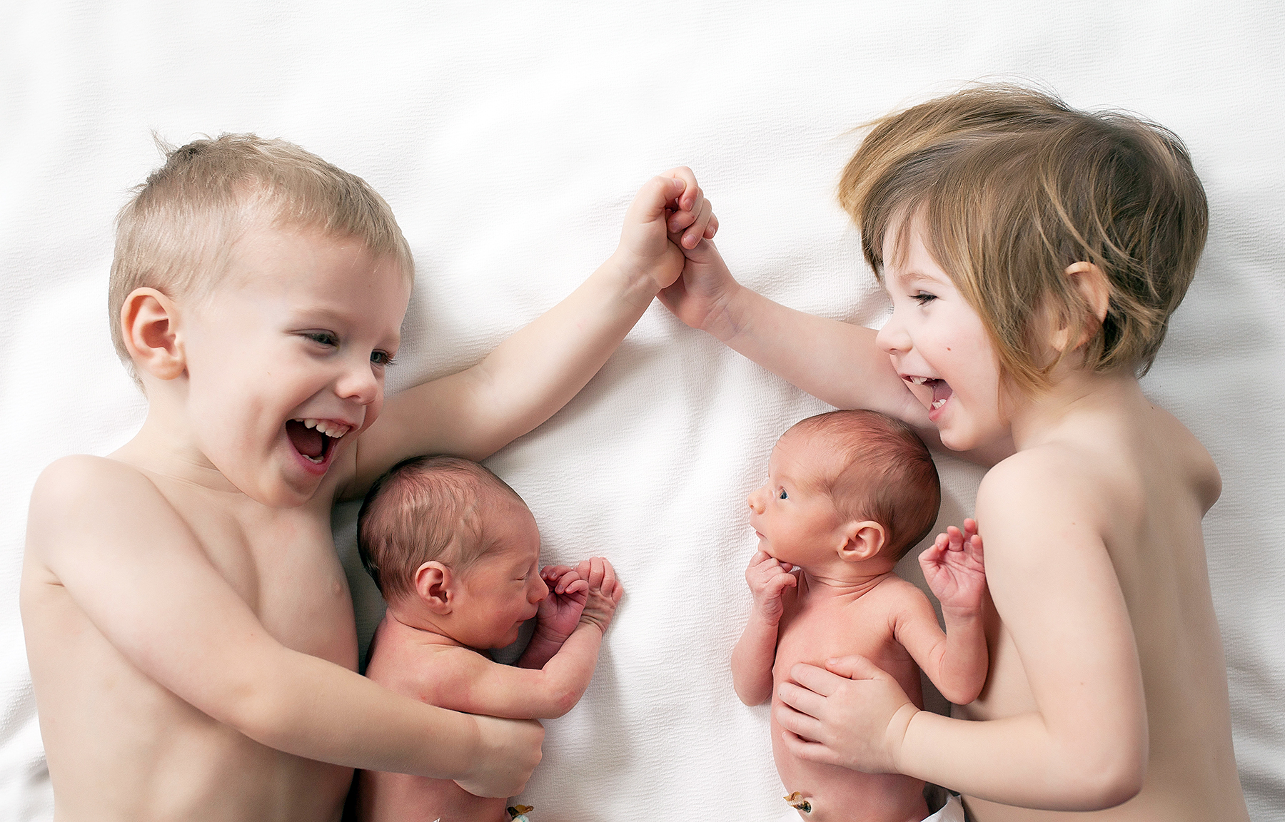 This Photo of Toddler Twins Cuddling Newborn Twin Sisters Is Too Cute
