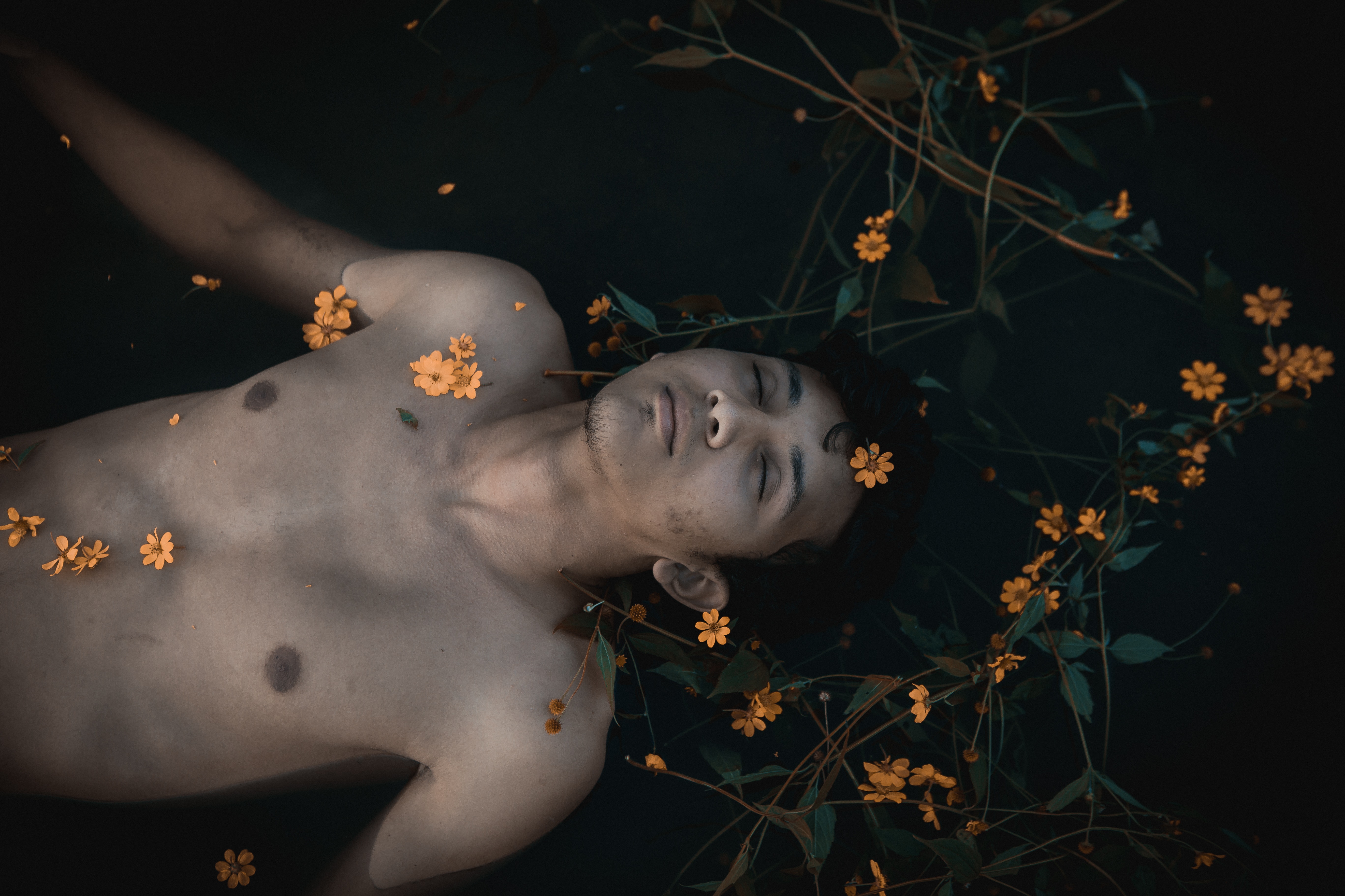 Topless man with orange flowers photo