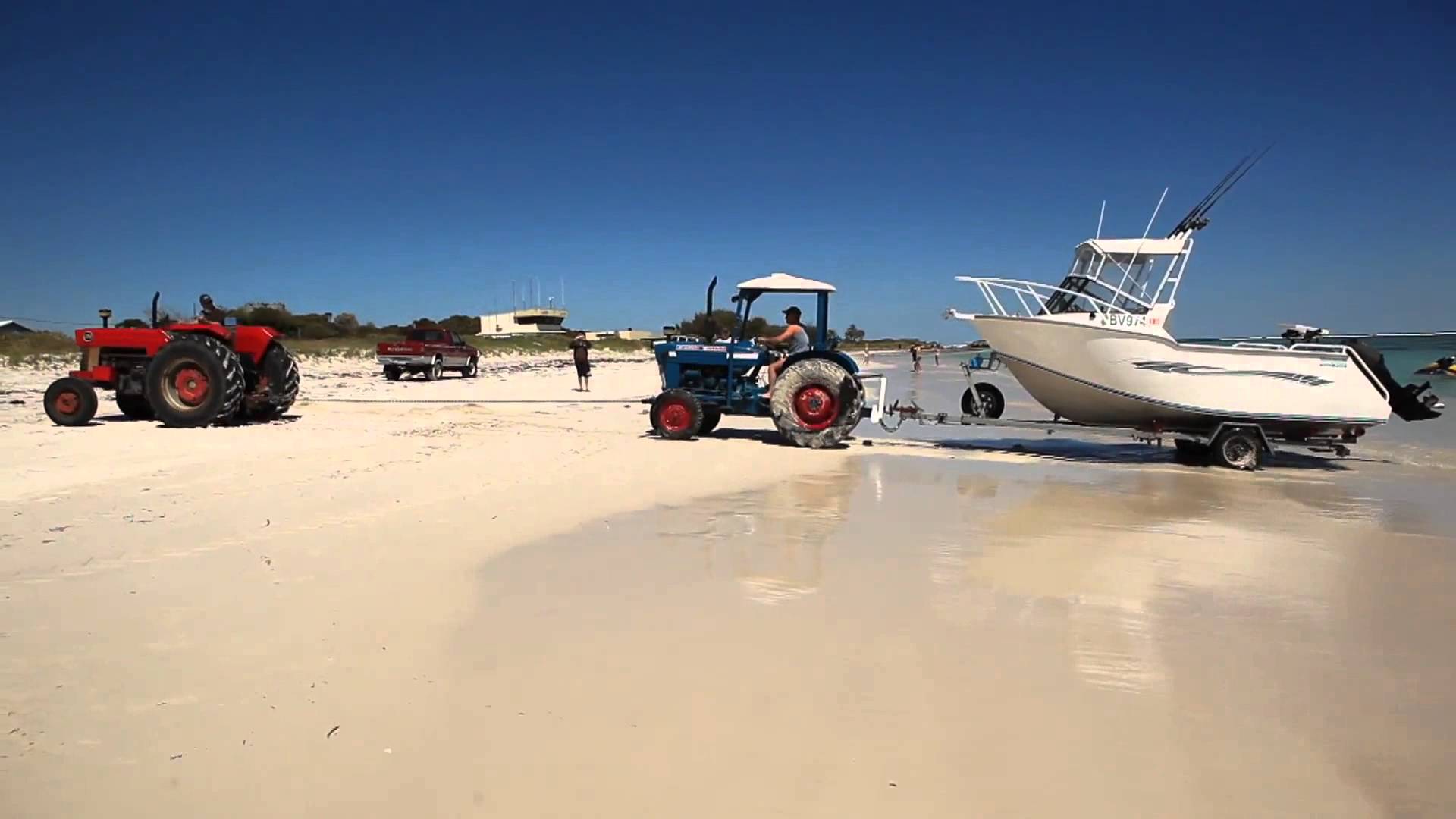 Lancelin tractor pulls bogged tractor from surf - YouTube