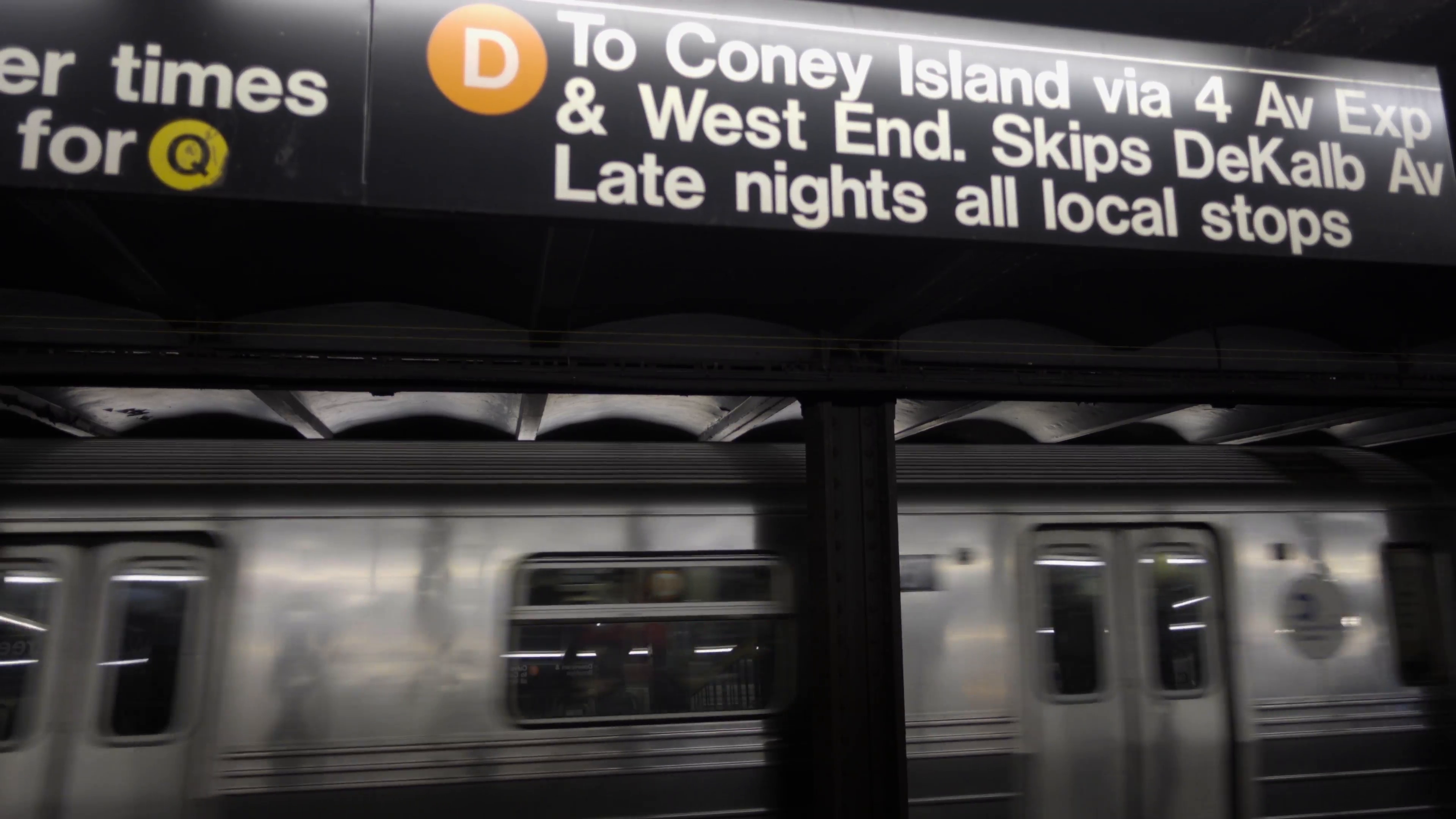 sign for D train to Coney Island with subway passing from platform ...