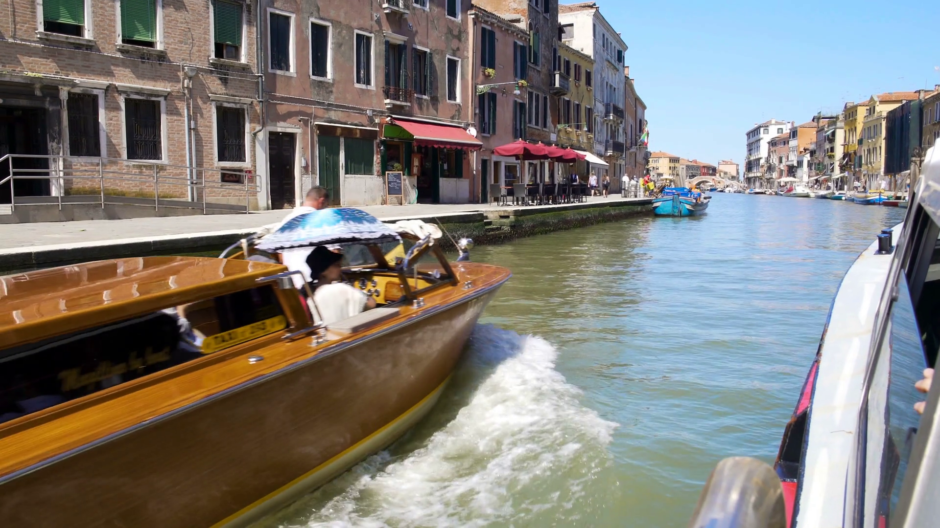 Tourists travelling by water taxi along Venice canal, transportation ...