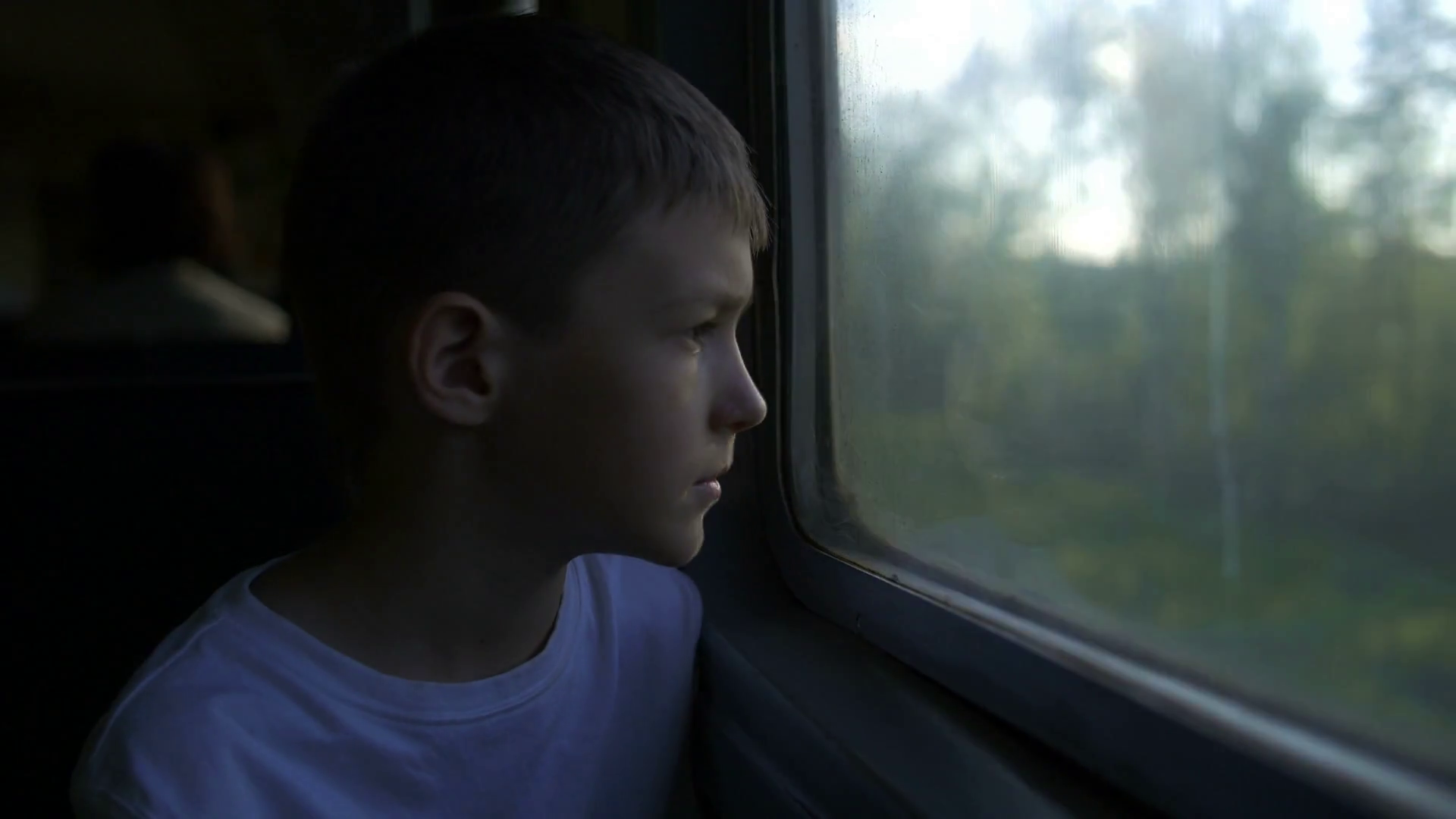 boy travelling by train looking in the window, Sun rays Stock Video ...