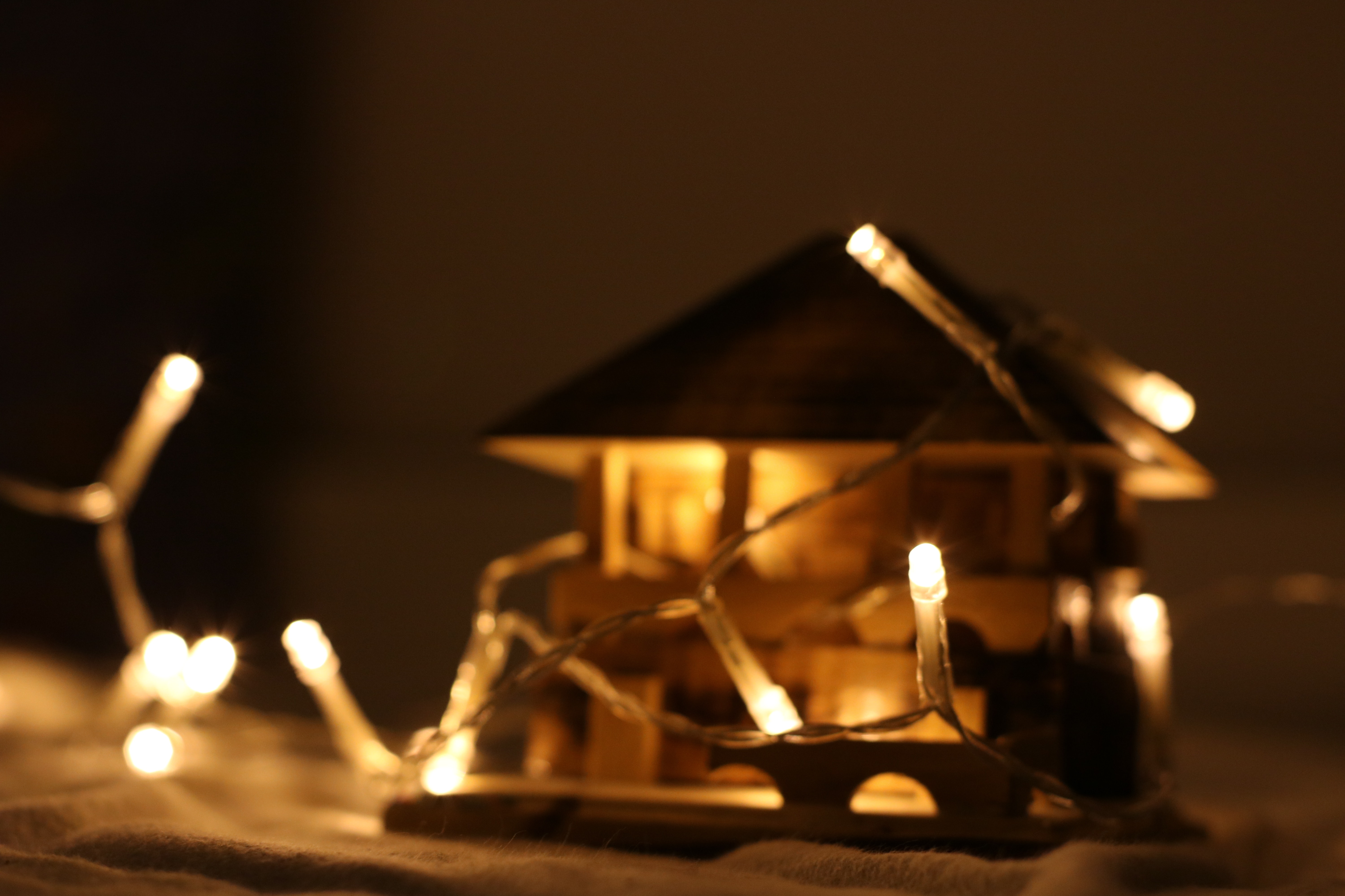 Turned on string light on miniature house photo