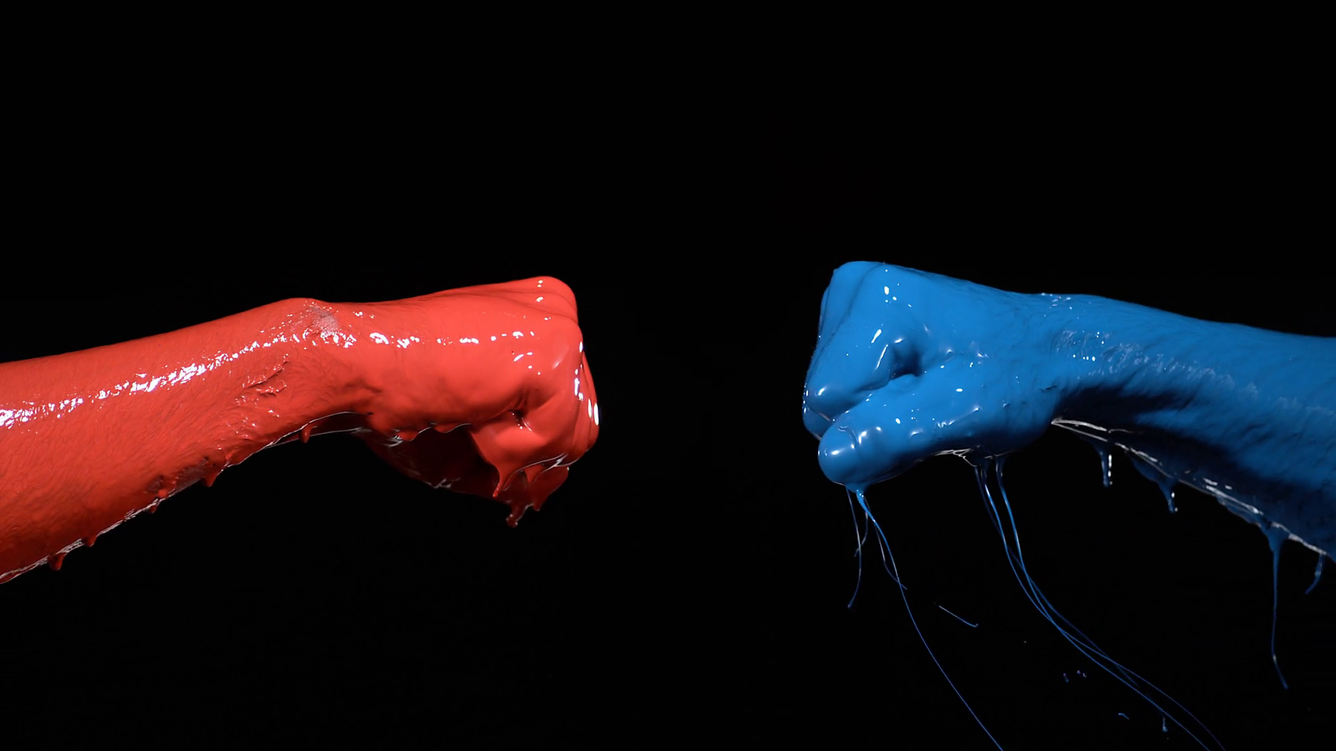 Two fists painted blue and red punching each other. Shot with high ...